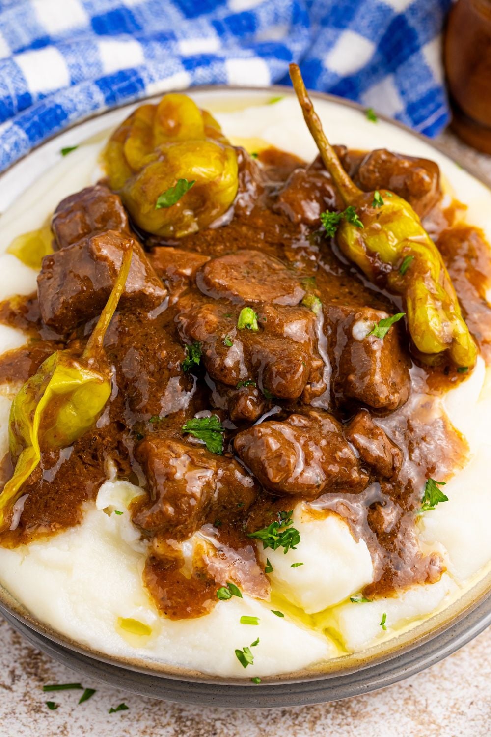 Crockpot Mississippi Steak Bites on plate with view of potatoes underneath the meat