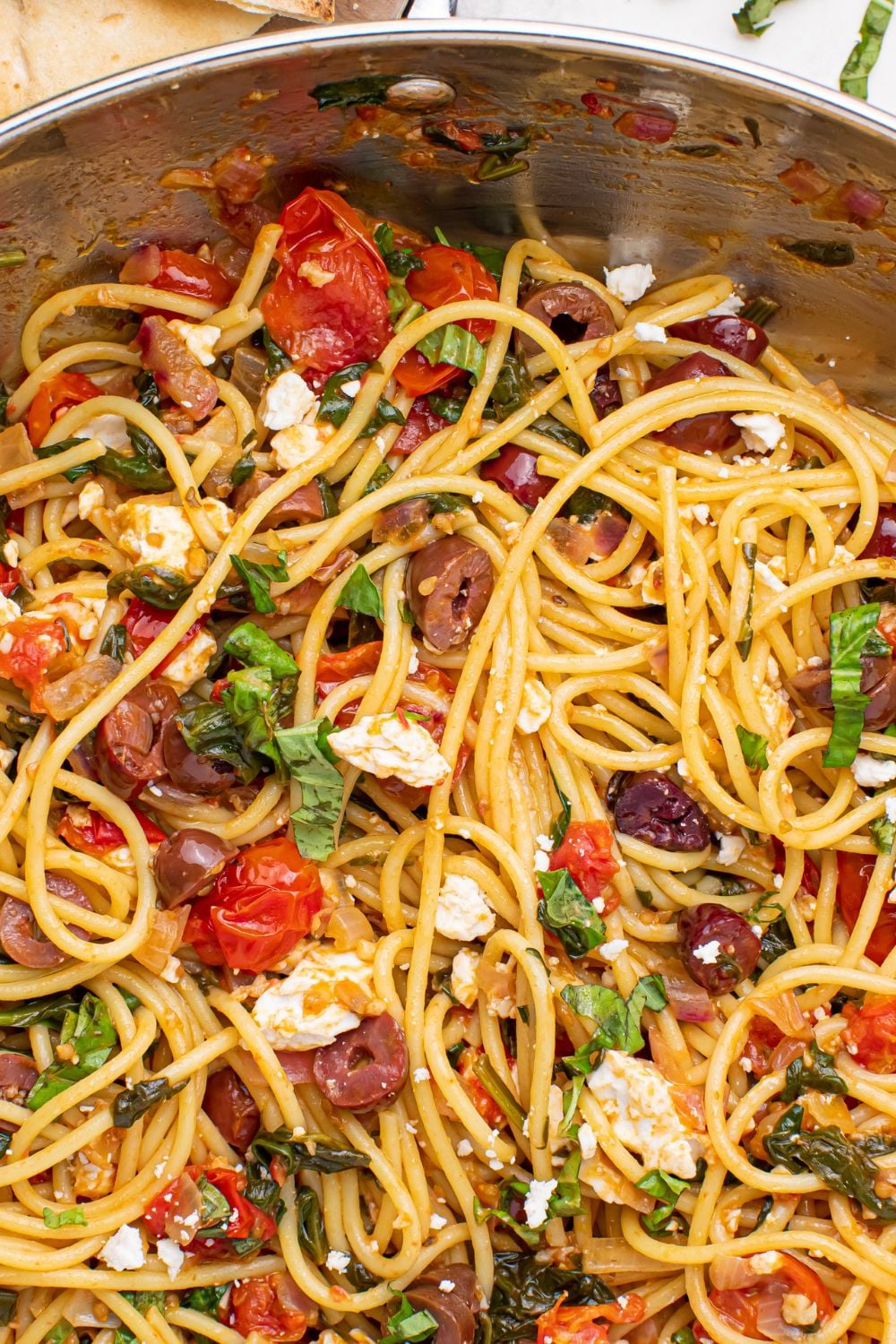 Greek Spaghetti in a pan with close up view of pasta and veggies 