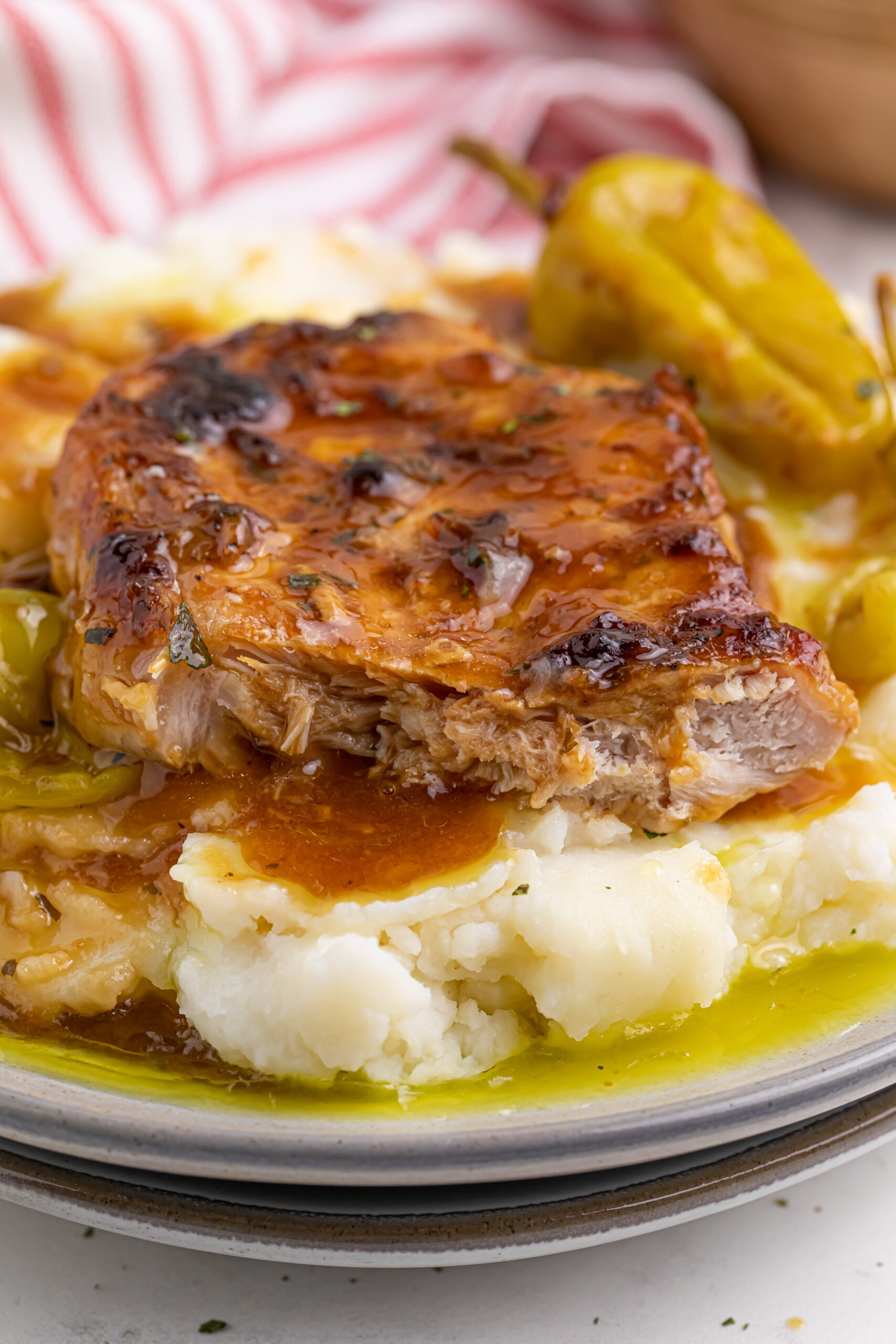 Mississippi pork chops over mashed potatoes on a white plate