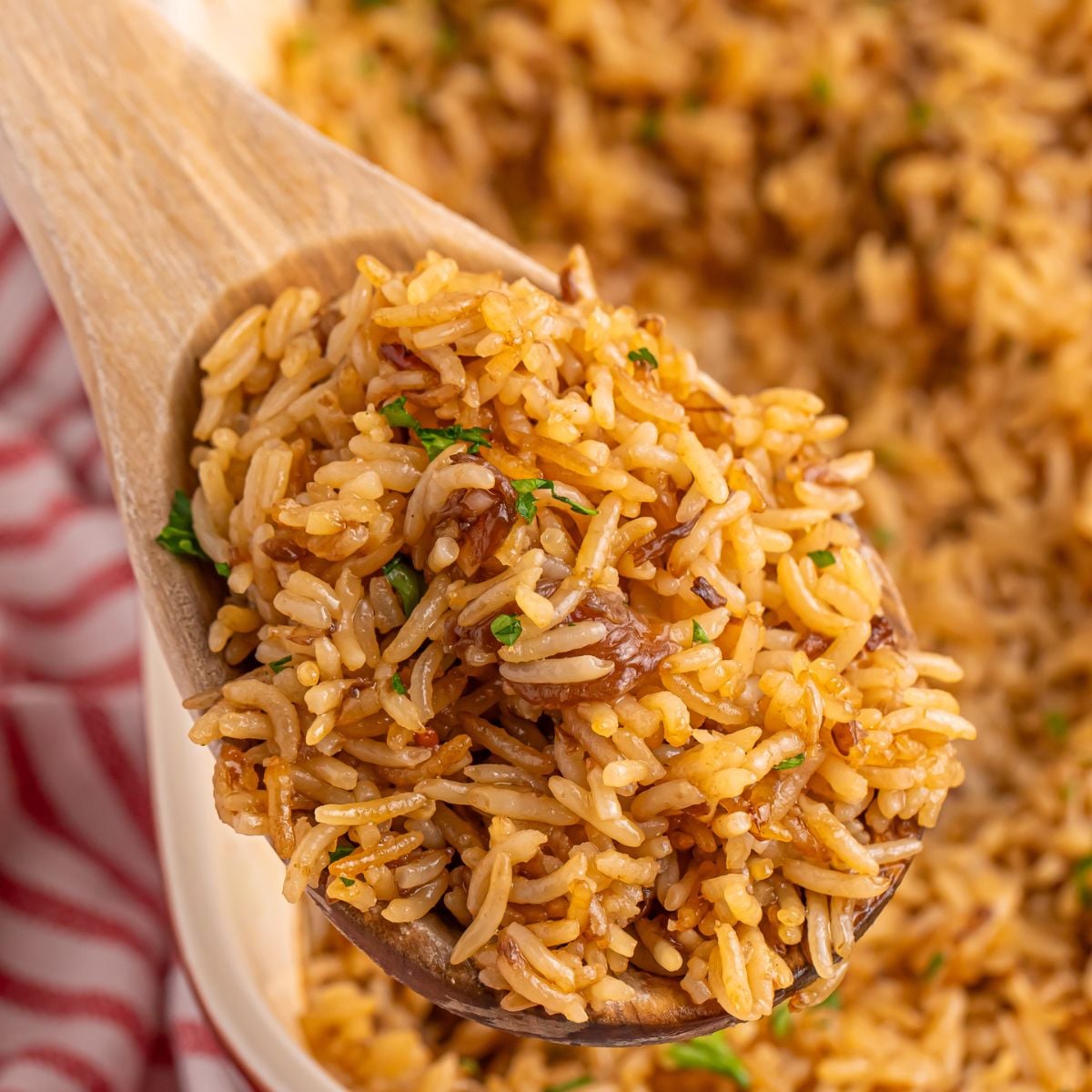 Stick of Butter Rice in pan with a wooden spoonful on table