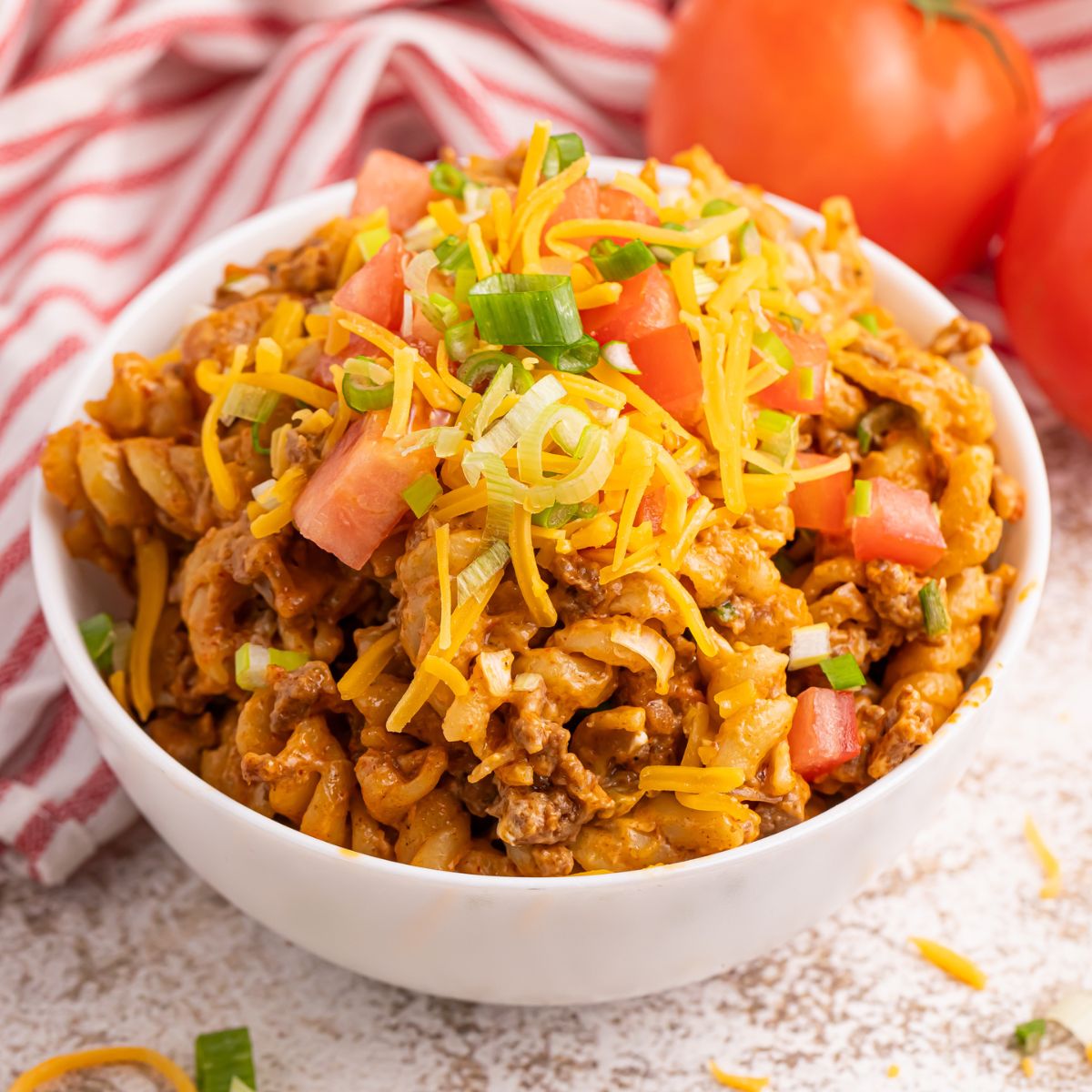 Taco Macaroni and Cheese in a bowl with shredded cheese on top