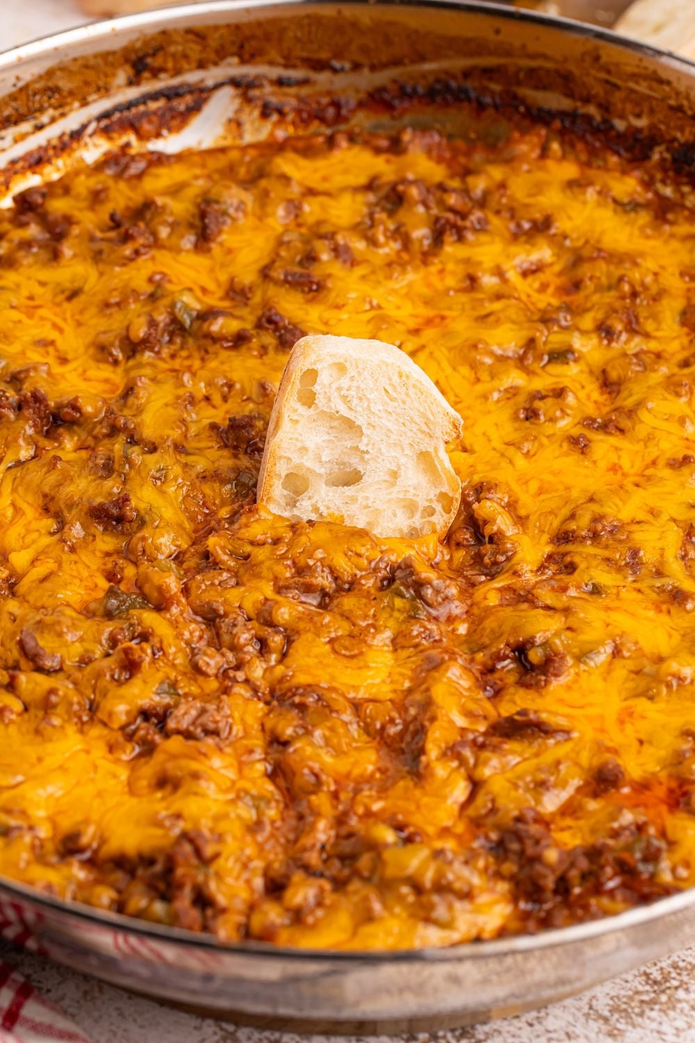 Sloppy Joe Dip in a metal pan with a piece of bread in the center