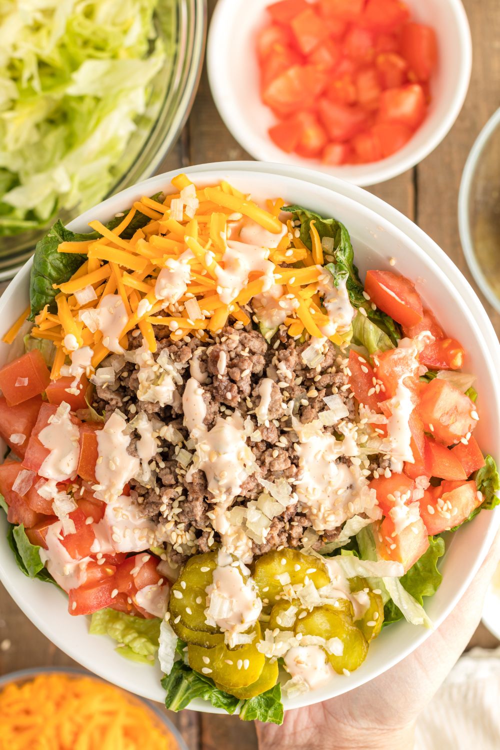 Big Mac Salad in bowl with overhead view with bowls of each ingredient around the salad
