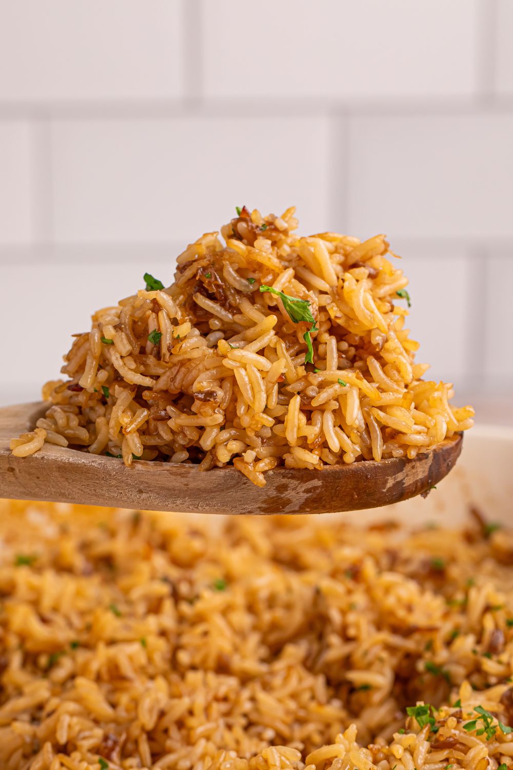 Stick of Butter Rice on a wooden spoon above pan