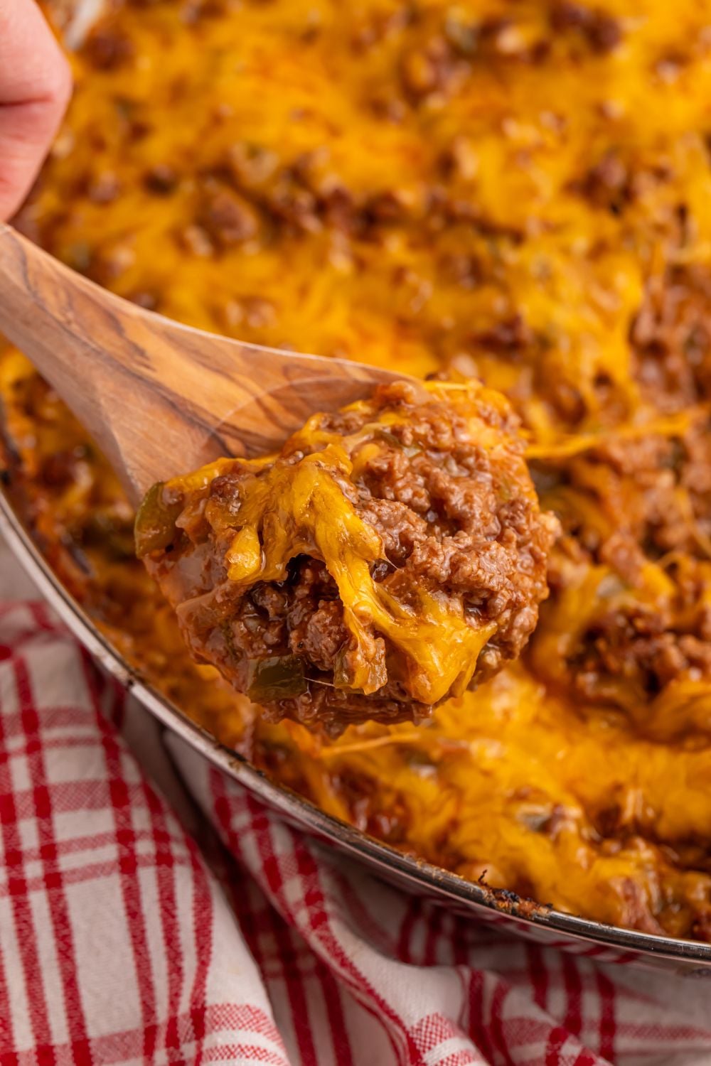 Sloppy Joe Dip in a pan with a wooden spoon with a bit of the dip sitting on the side of the pan
