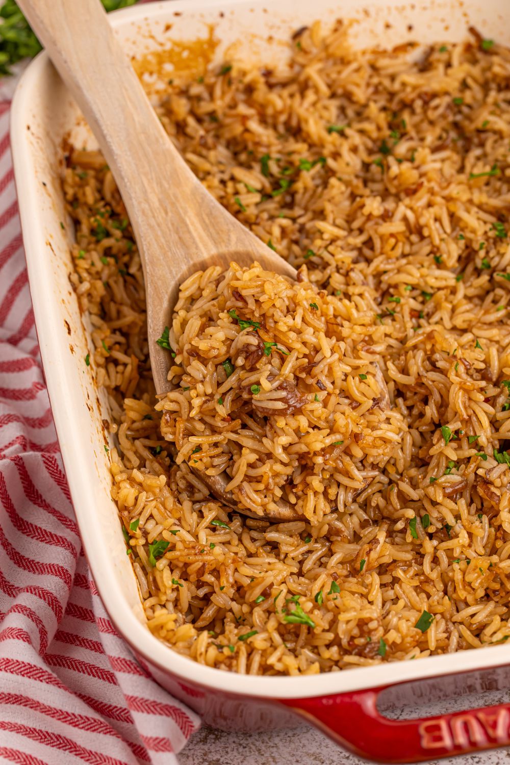 Stick of Butter Rice in a pan with a wooden spoon with some rice on it sitting in pan