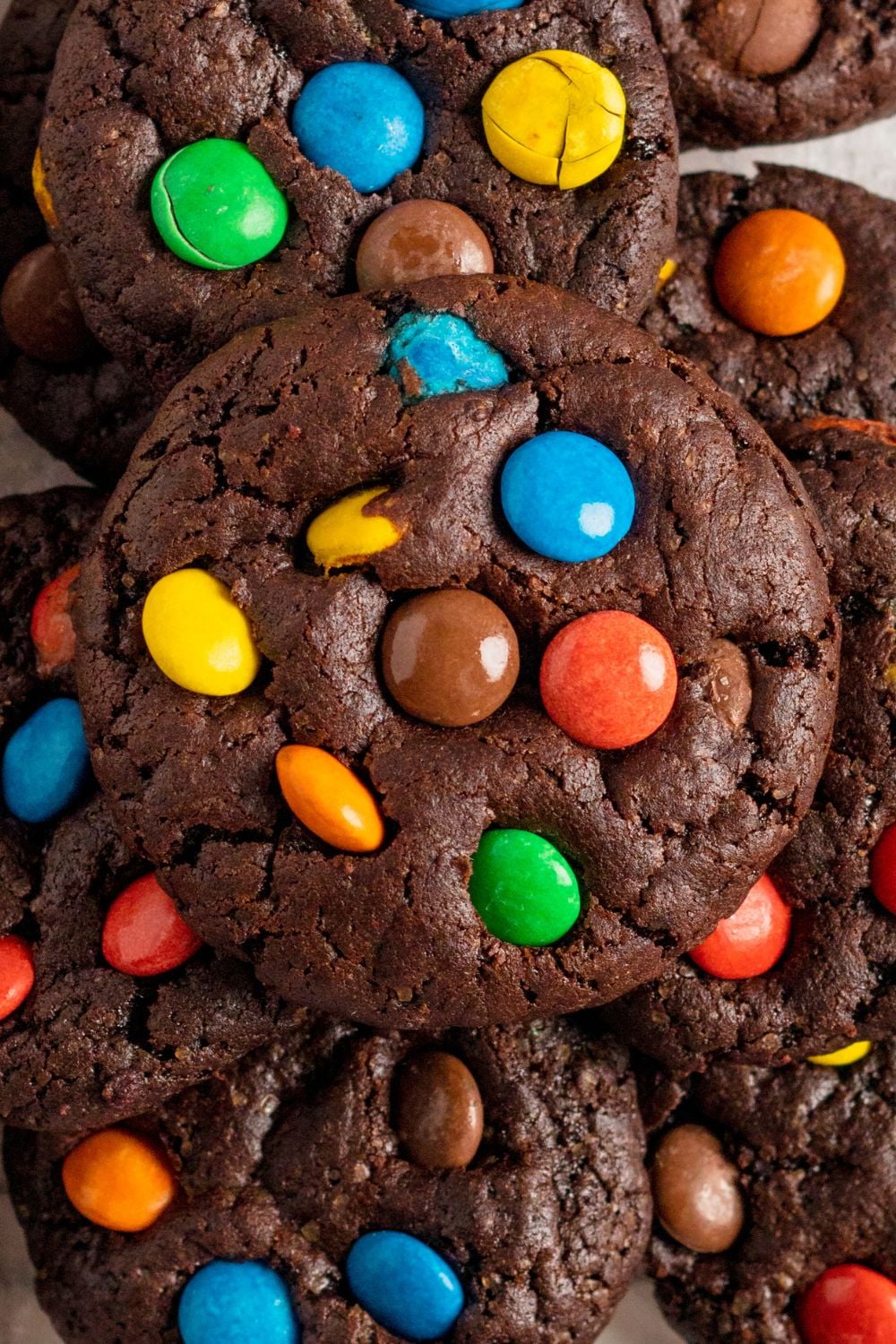 Chocolate M&M Cookies stacked on top of each other, with a close up to see all the M&Ms in the cookie