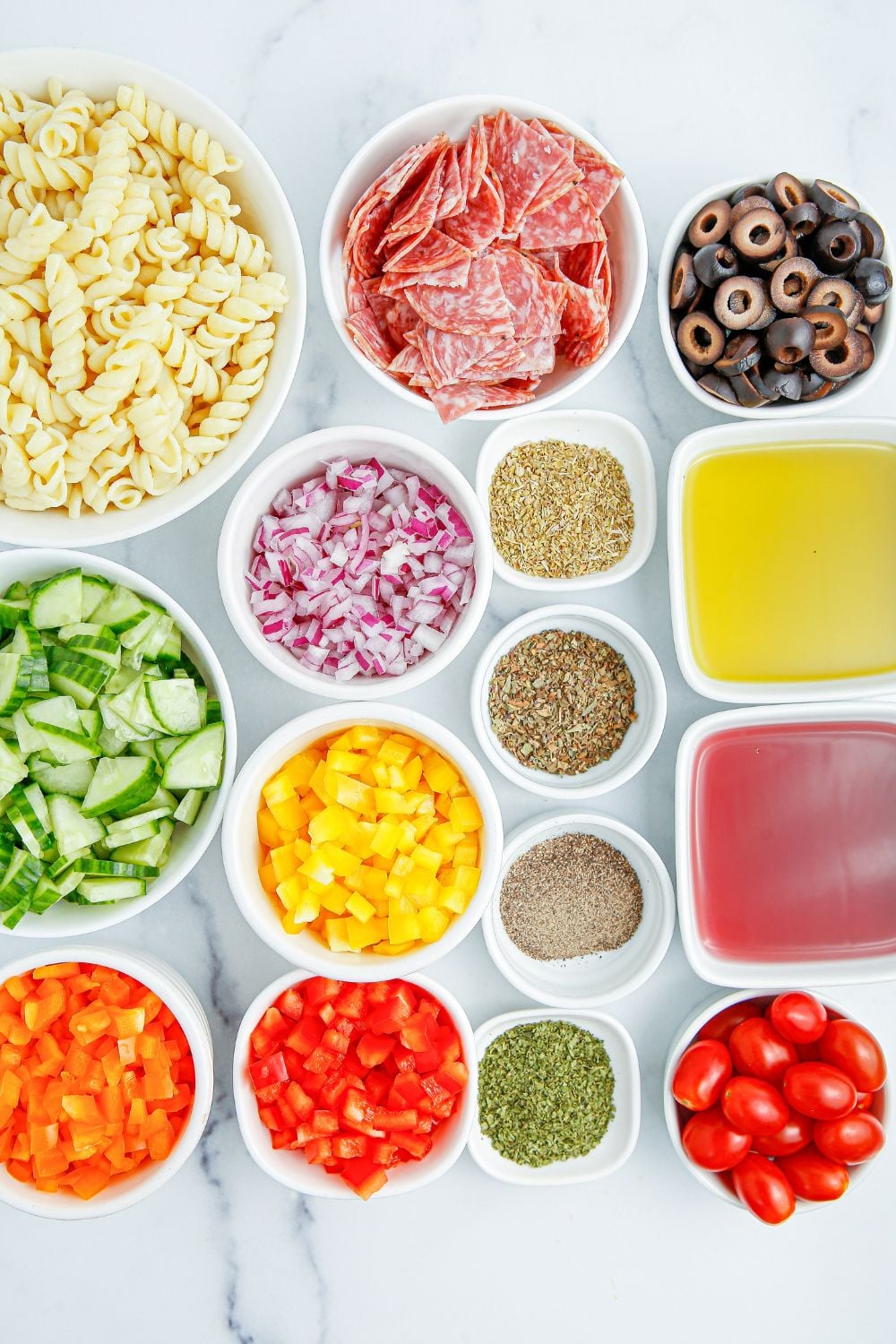 ingredients for Summer Pasta Salad in small white bowls on table 