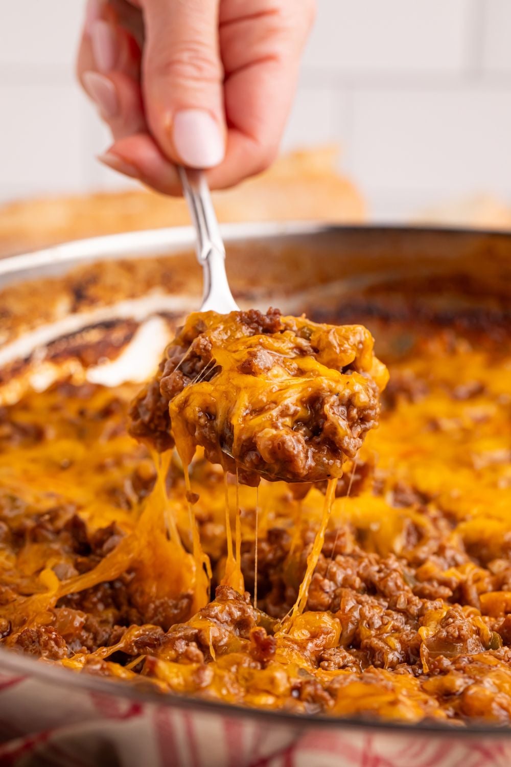 Sloppy Joe Dip in pan being lifted out of pan with a spoon