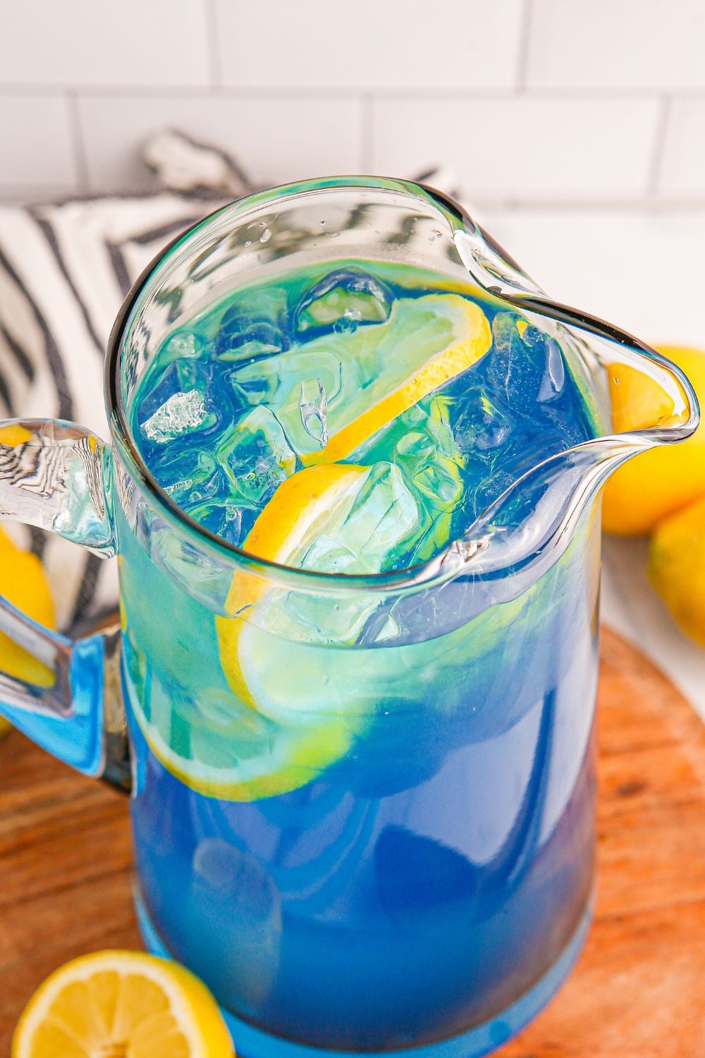 Blue Raspberry Lemonade in a pitcher on table with a towel behind it