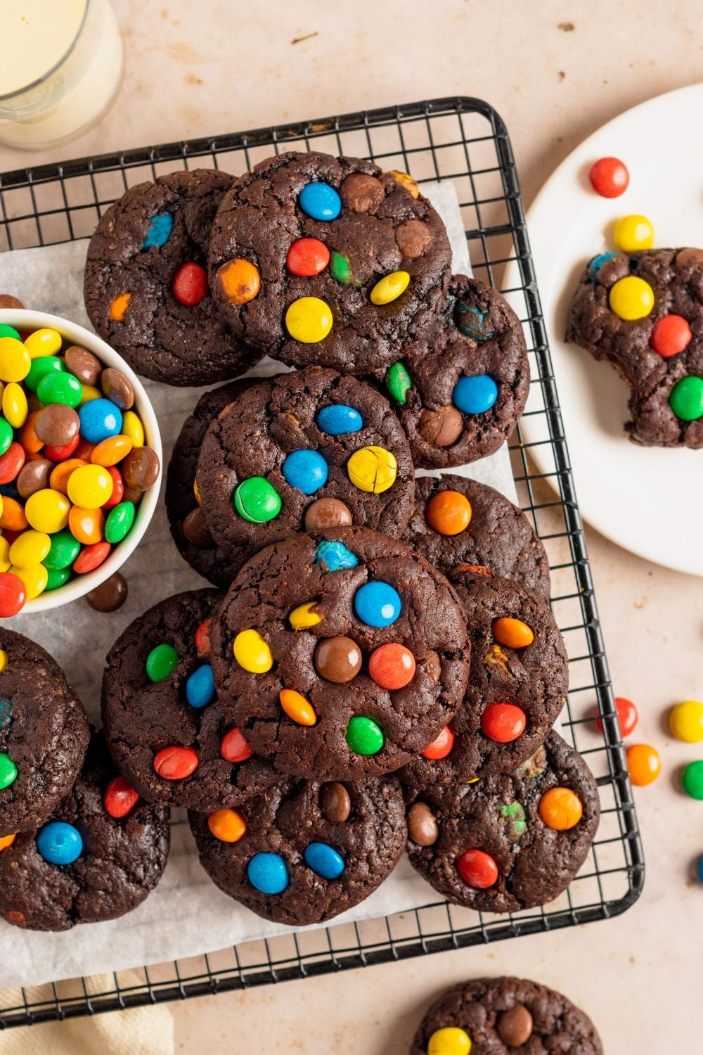 Chocolate M&M Cookies on a coolig rack with a bowl of M&Ms to the side of tray