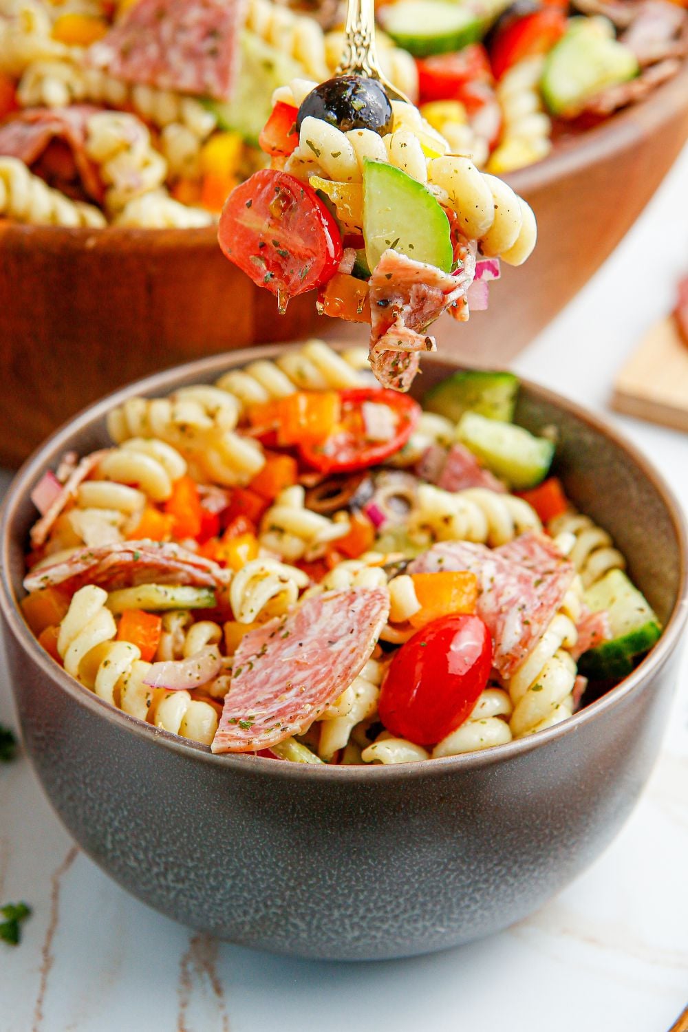 Summer Pasta Salad in a bowl with a fork with some of the salad on it 