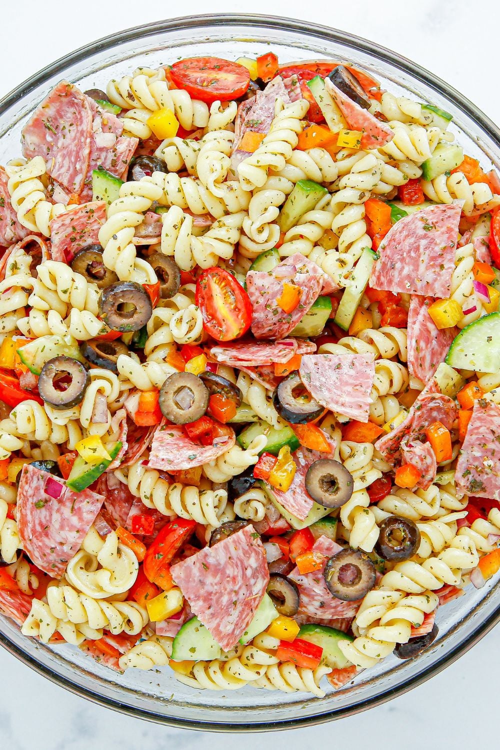 Summer Pasta Salad in a glass bowl mixed up 