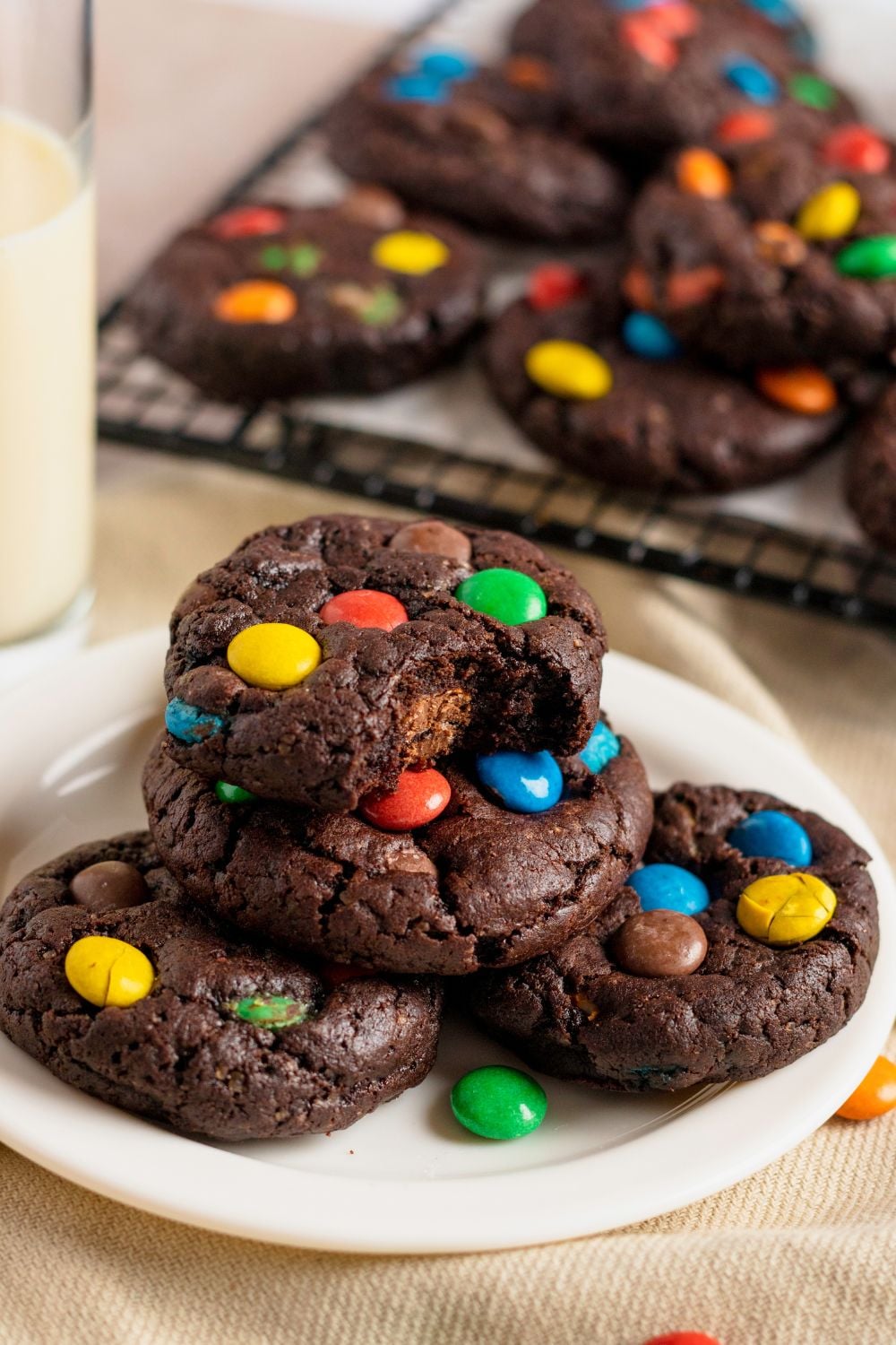 Chocolate M&M Cookies on a plate with one cookie with a bite taken out of it