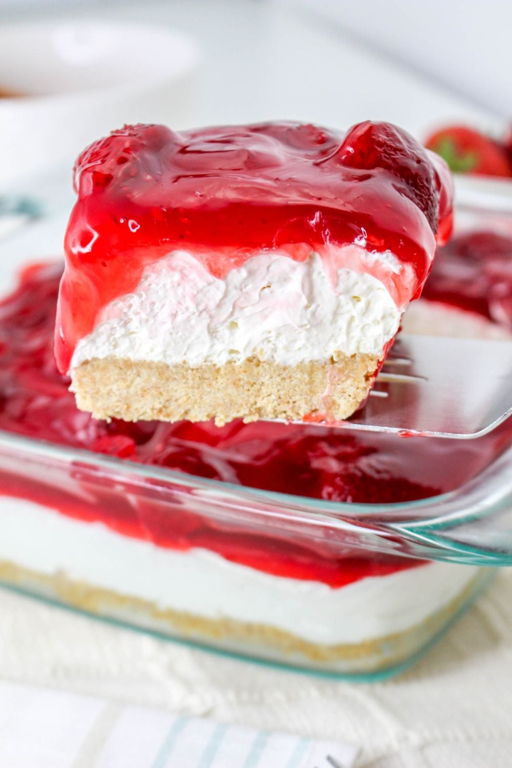 No Bake Strawberry Delight being lifted out of pan with spatula