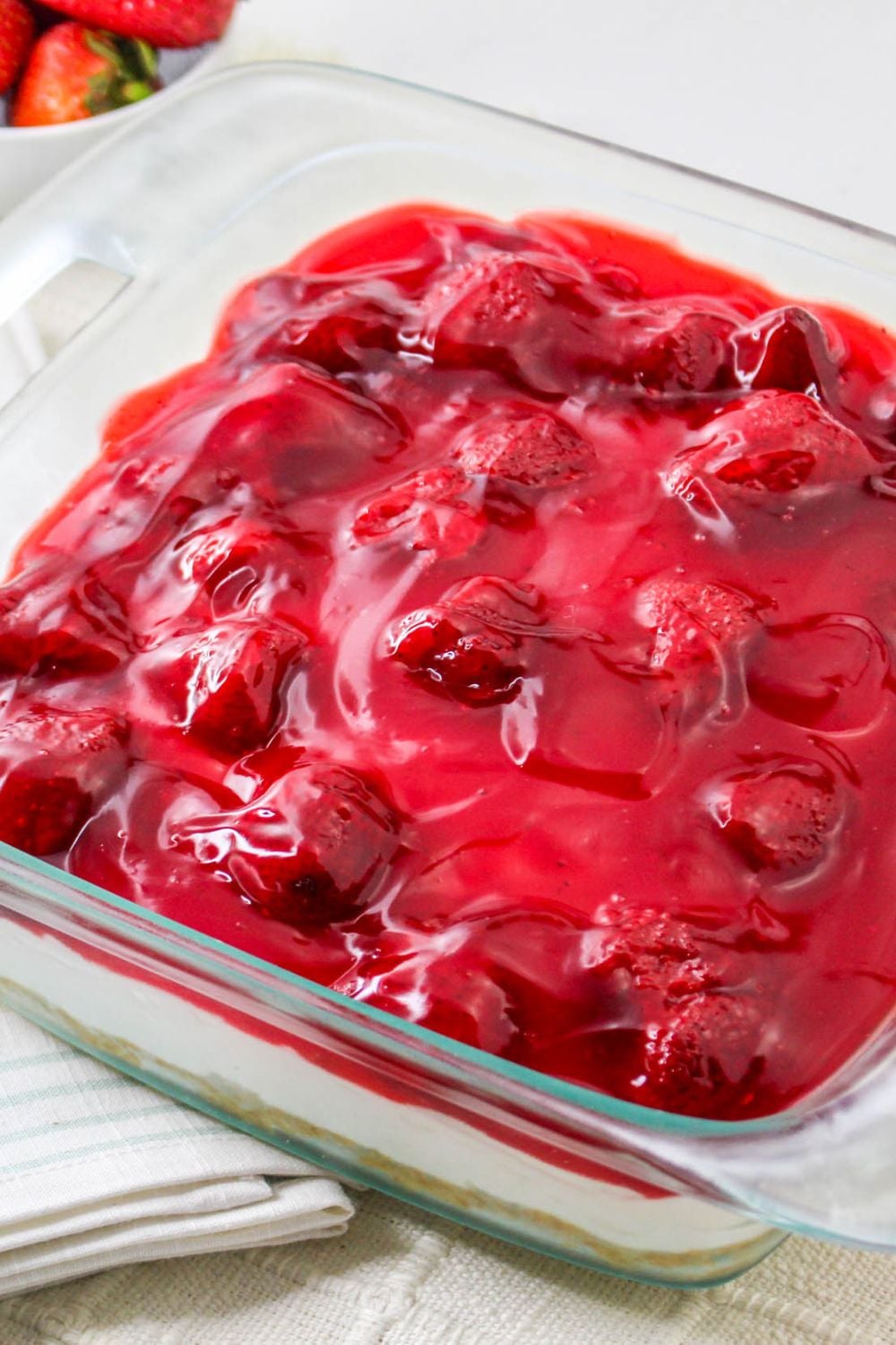 side view of No Bake Strawberry Delight in a glass pan on table