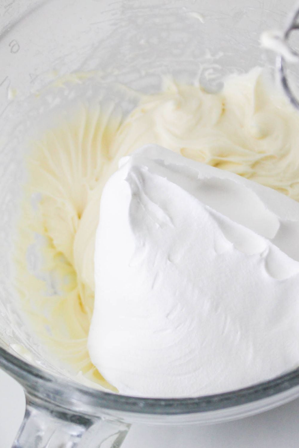 No Bake Strawberry Delight mixture in a bowl with whipped cream on top