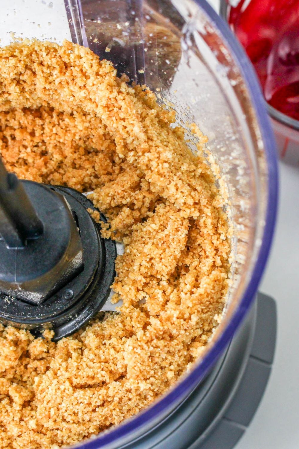 food processor with crushed crackers in it for No Bake Strawberry Delight