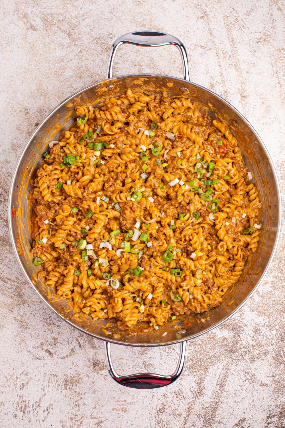 Taco Macaroni and Cheese in a skillet with garnish on top of the pan