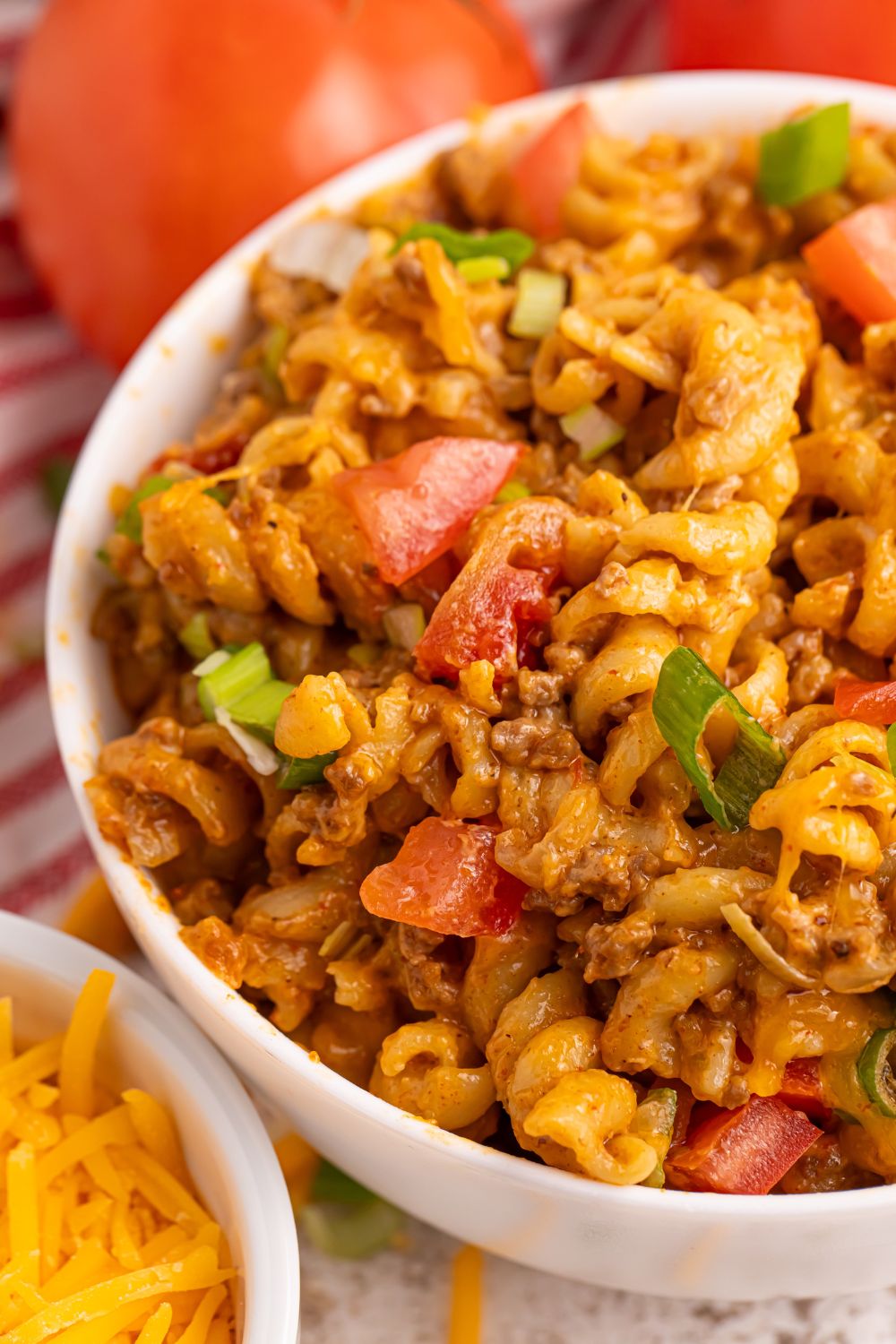 Taco Macaroni and Cheese in a bowl with tomatoes and green onions on top