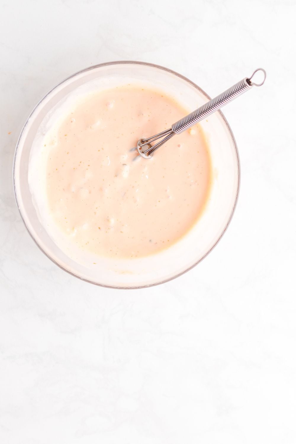 Big Mac Salad dressing in a glass bowl mixed up with whisk 