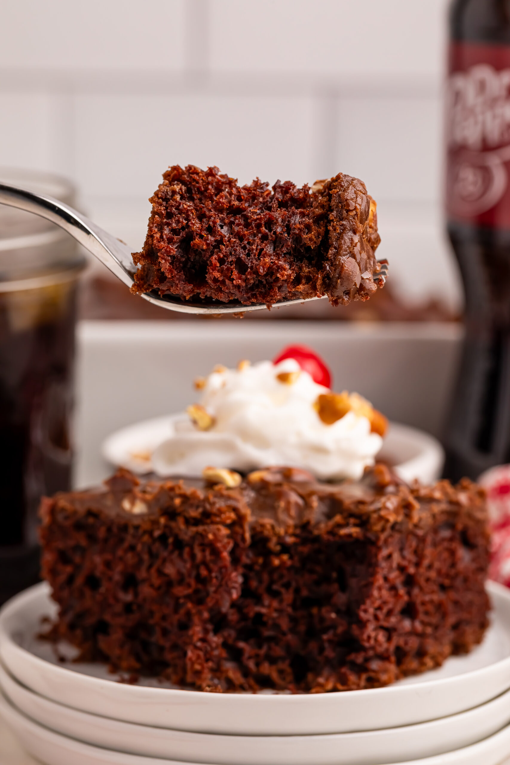 slice of Dr. Pepper Cake on plate with a fork with a bite on it