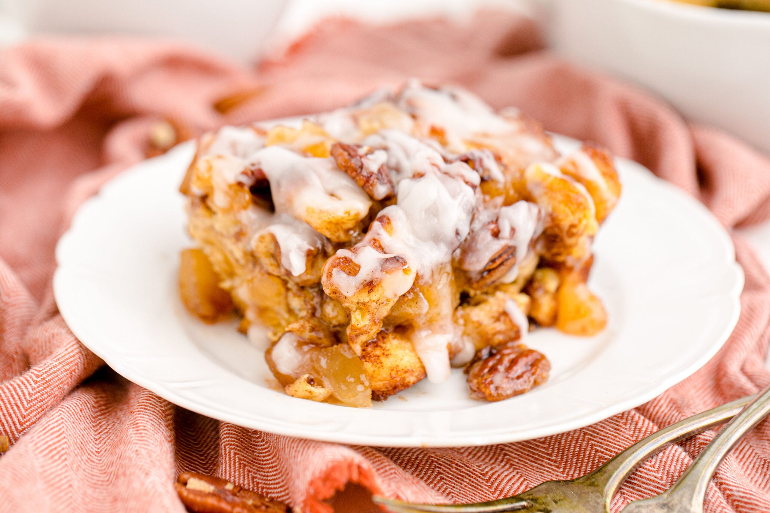 Cinnamon Roll Casserole on a white plate covered in icing