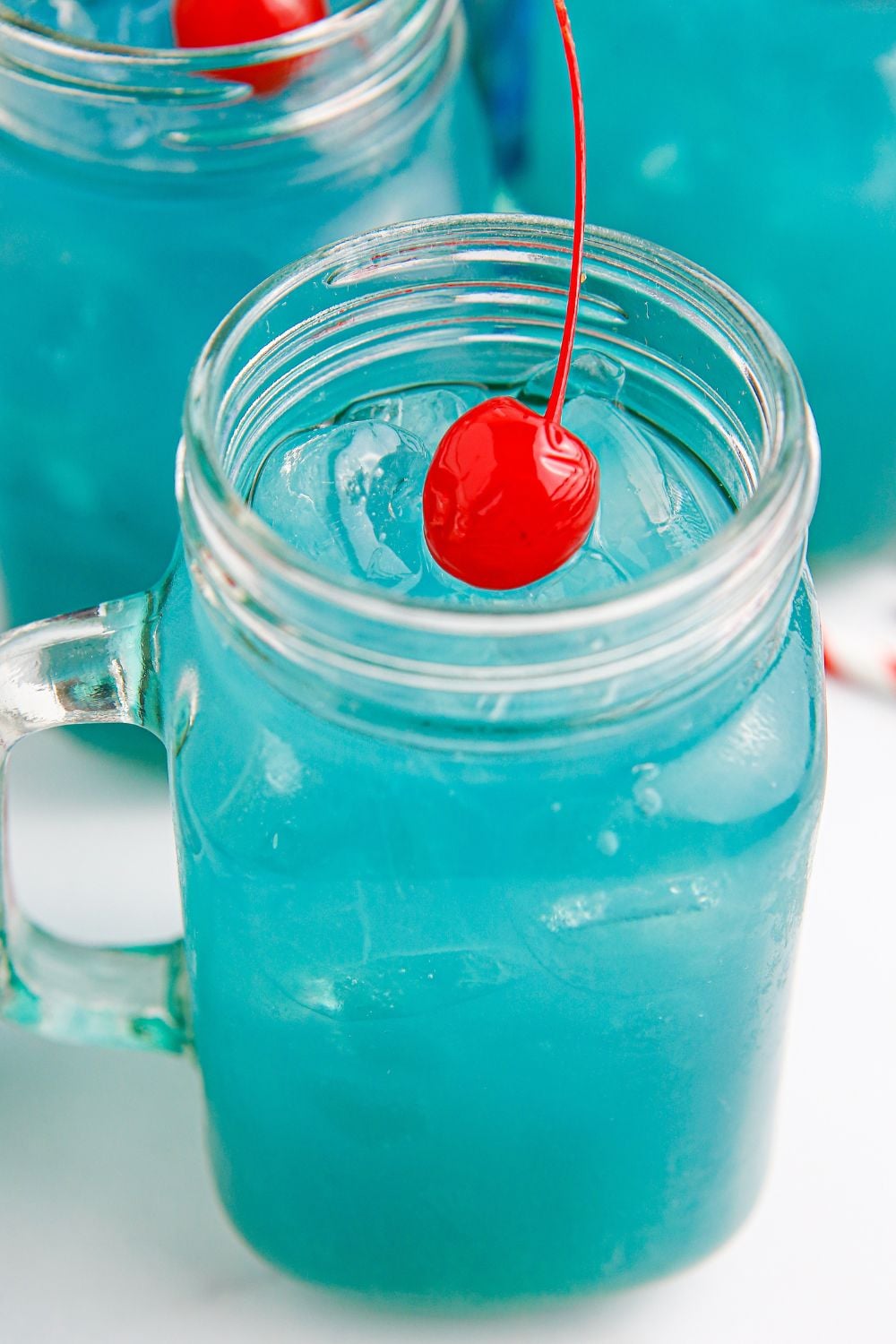 blue hurricane drink in glasses sitting on table