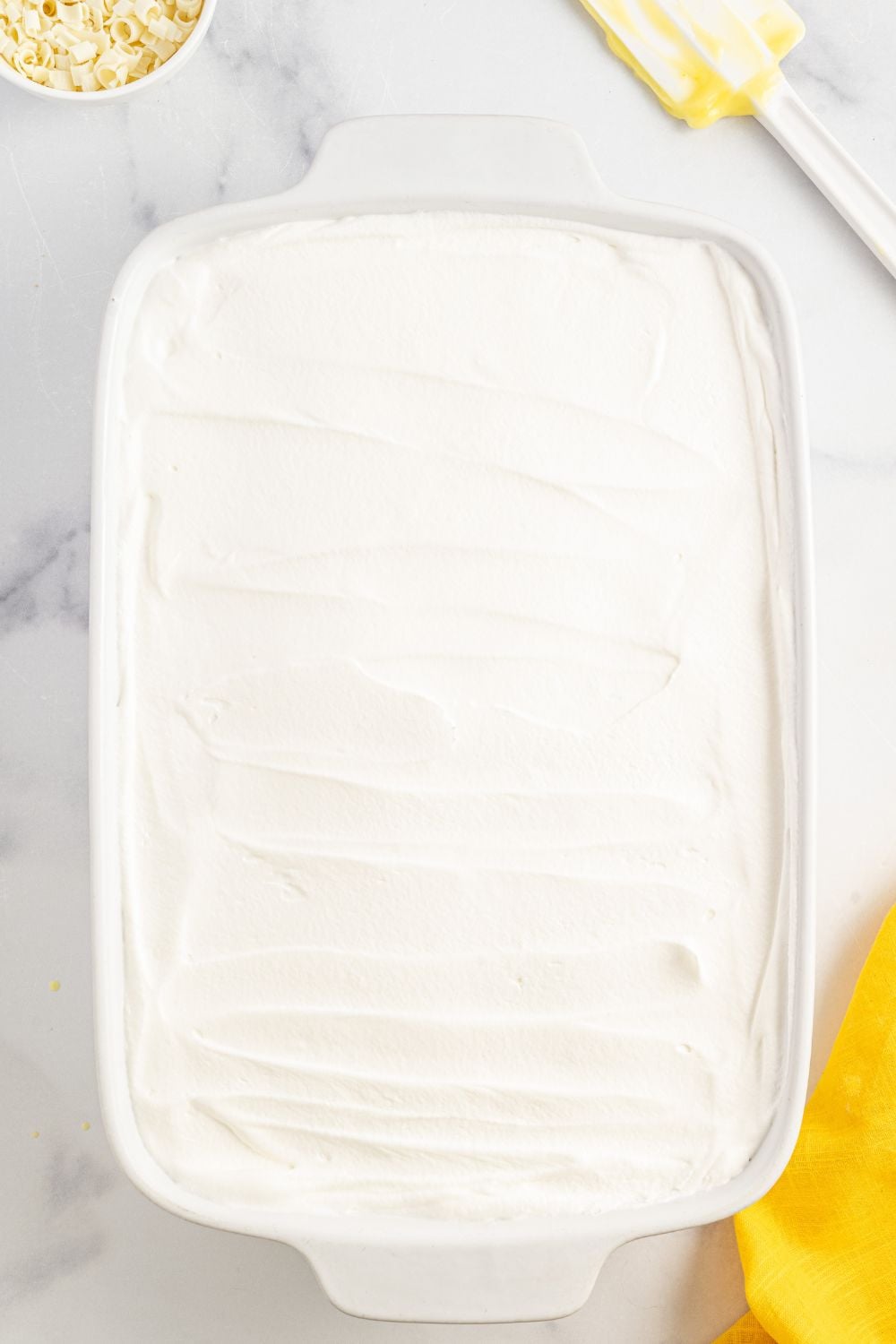whipped cream spread over the op of he Lemon Blueberry Lush dessert in pan