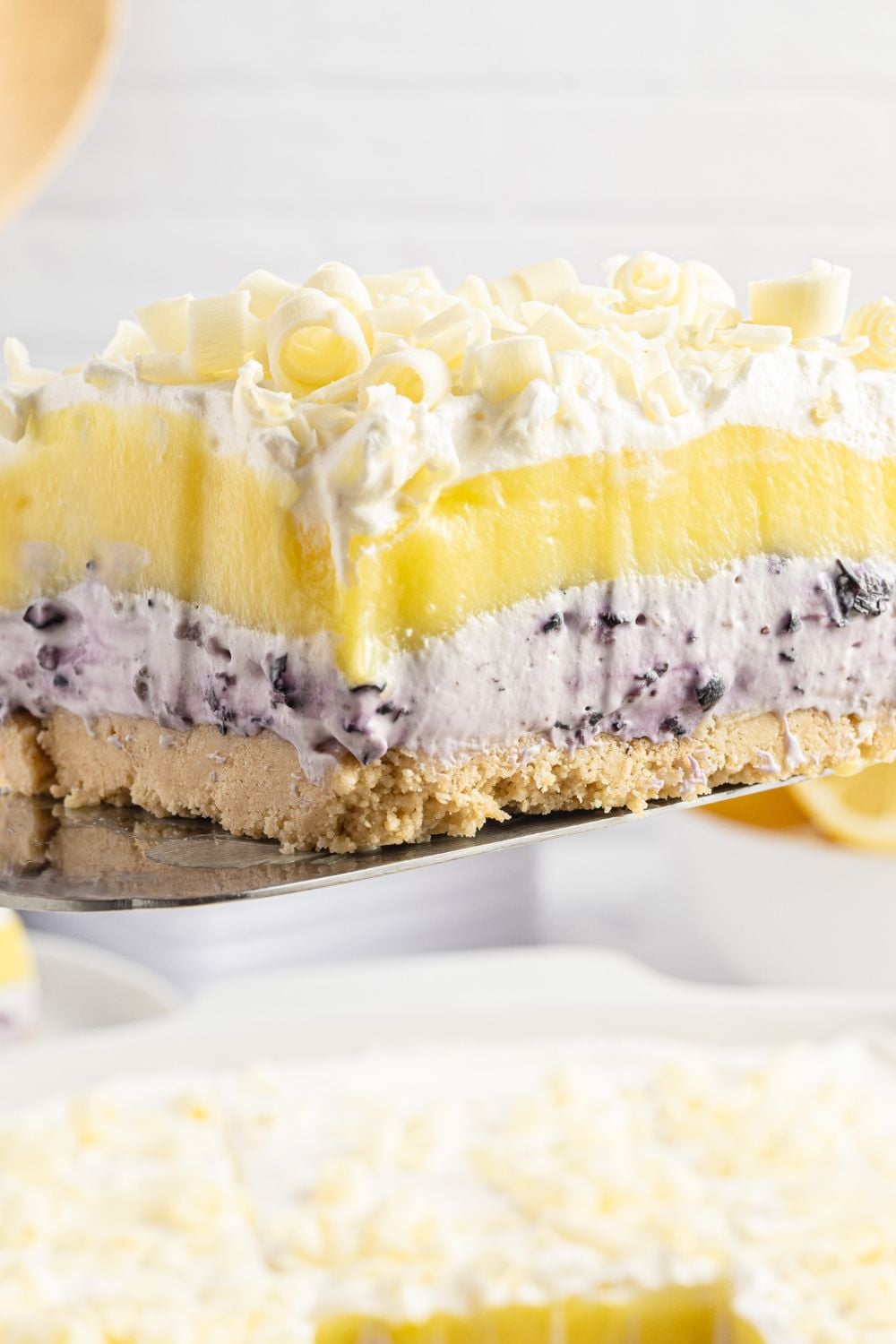 Lemon Blueberry Lush dessert sliced and being lifted out of pan