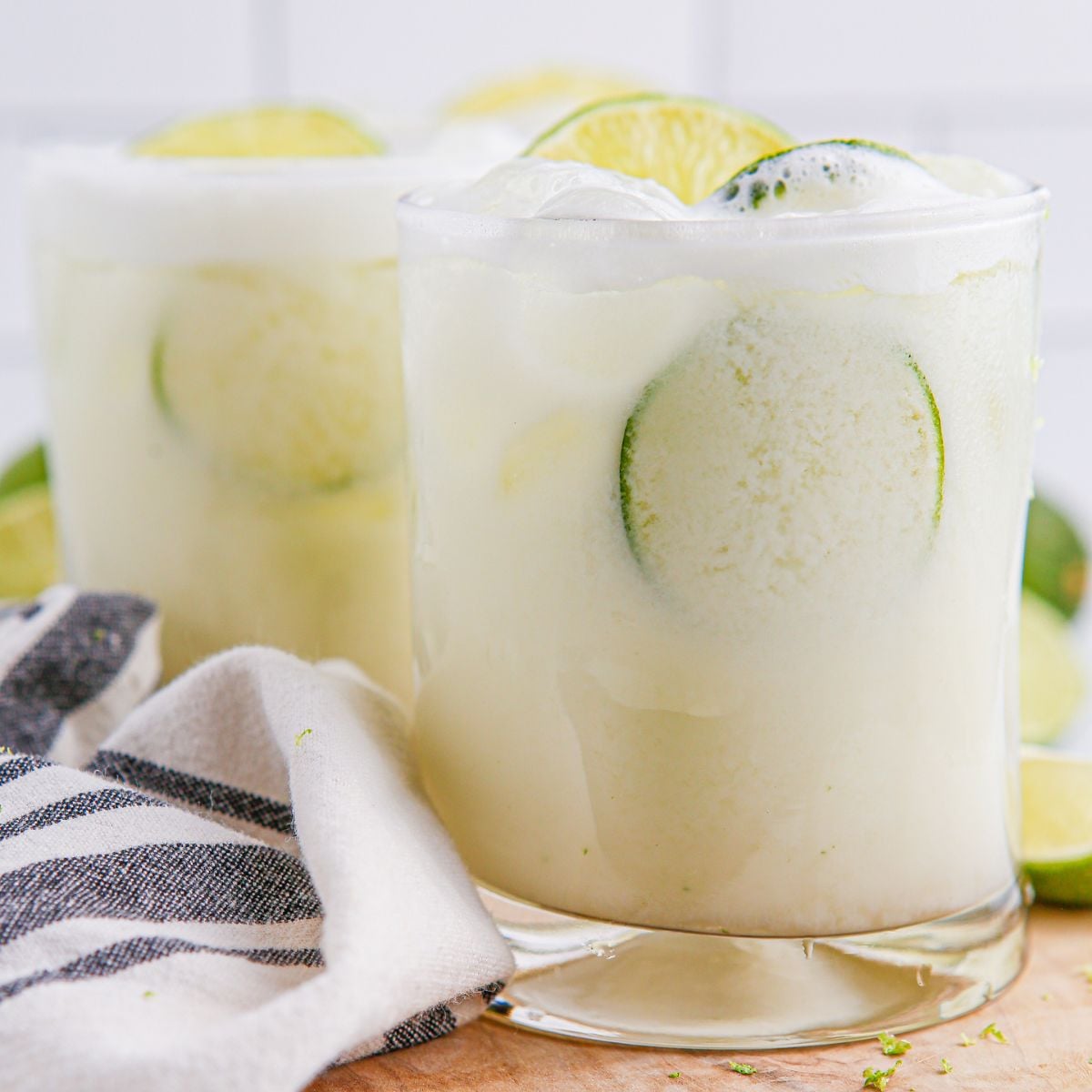 Brazilian Limeades in glasses on table with a towel around it