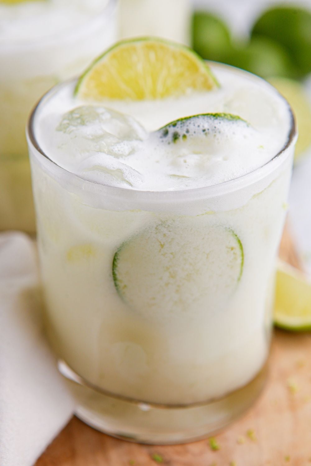 creamy limemade in glasses with limes and ice in it sitting on table