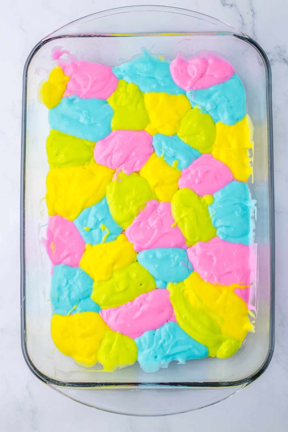 wet colored batte for the Easter Poke Cake in a 9x13 baking dish