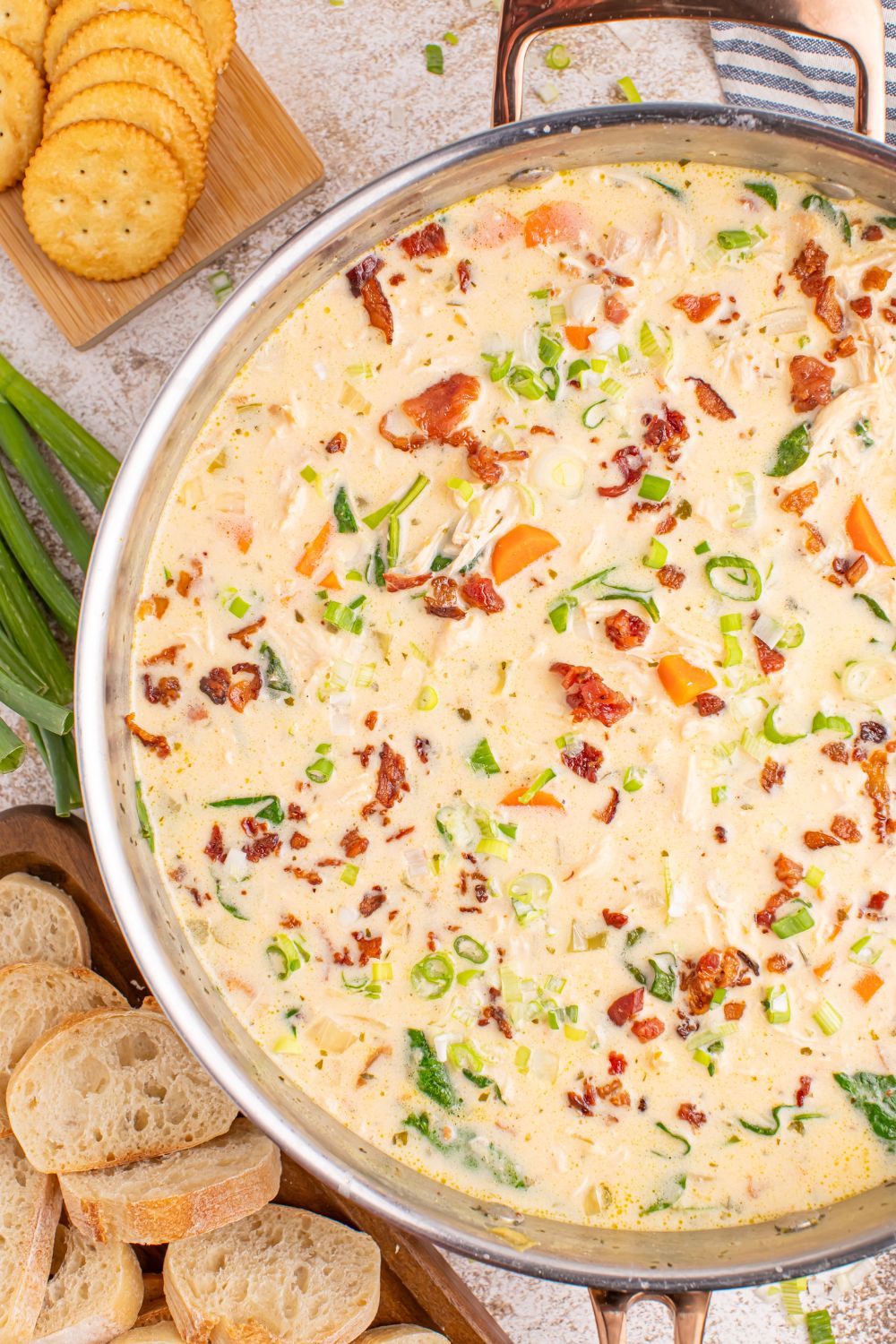 Crack Chicken Soup in a pan with crackers and sliced bread on the side