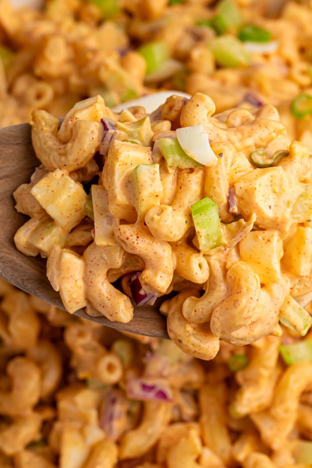 Deviled Egg Pasta Salad with a scoop in a spoon to show all the texture of salad