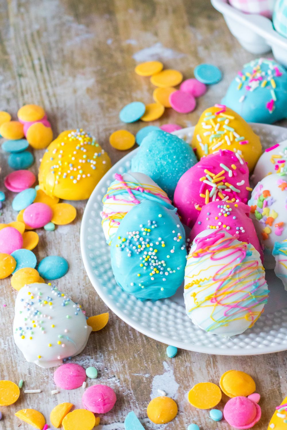 Easter Egg Oreo Truffles sat up on plate and a few scattered on a wooden table