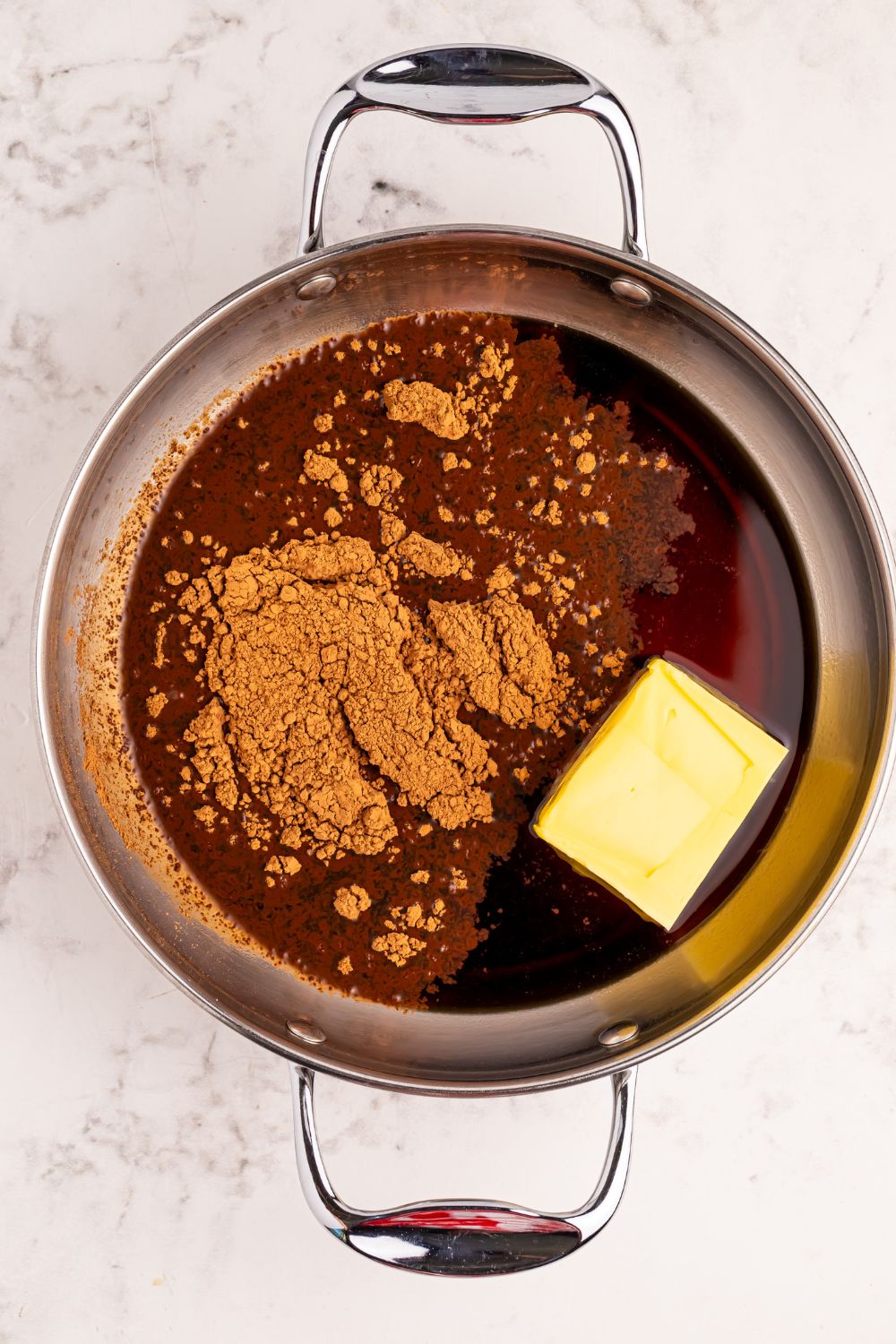 cocoa powder and butter in a metal pan on the table