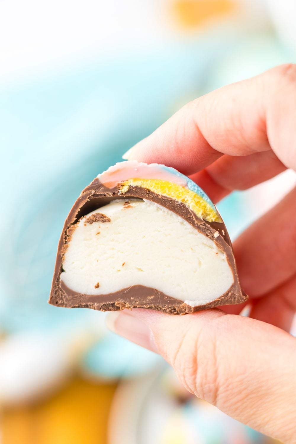 Easter Marshmallow Egg cut in half and showing the filling while being held in a hand 