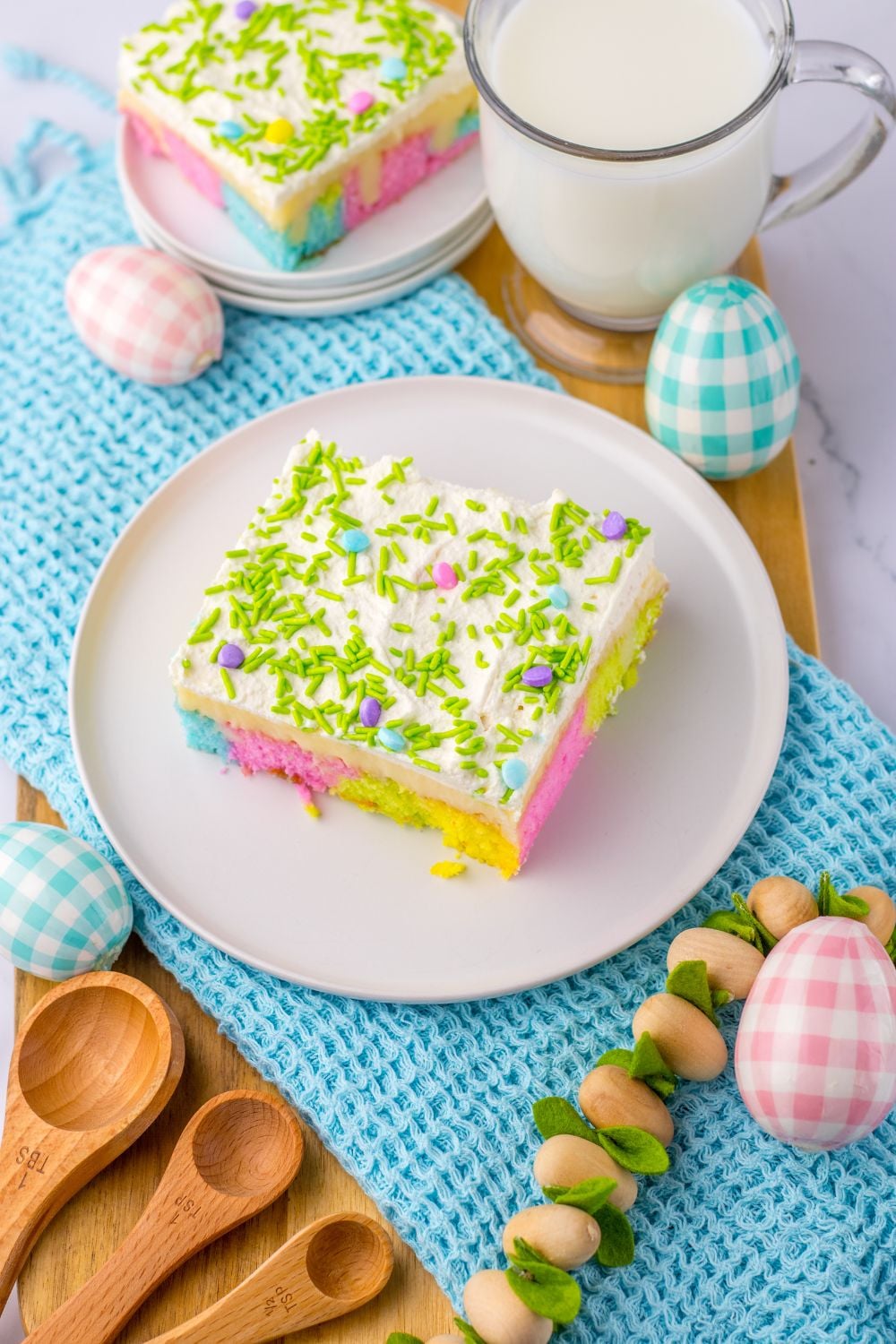overhead side view of cake on plates and decor around it showing the Easter Poke Cake