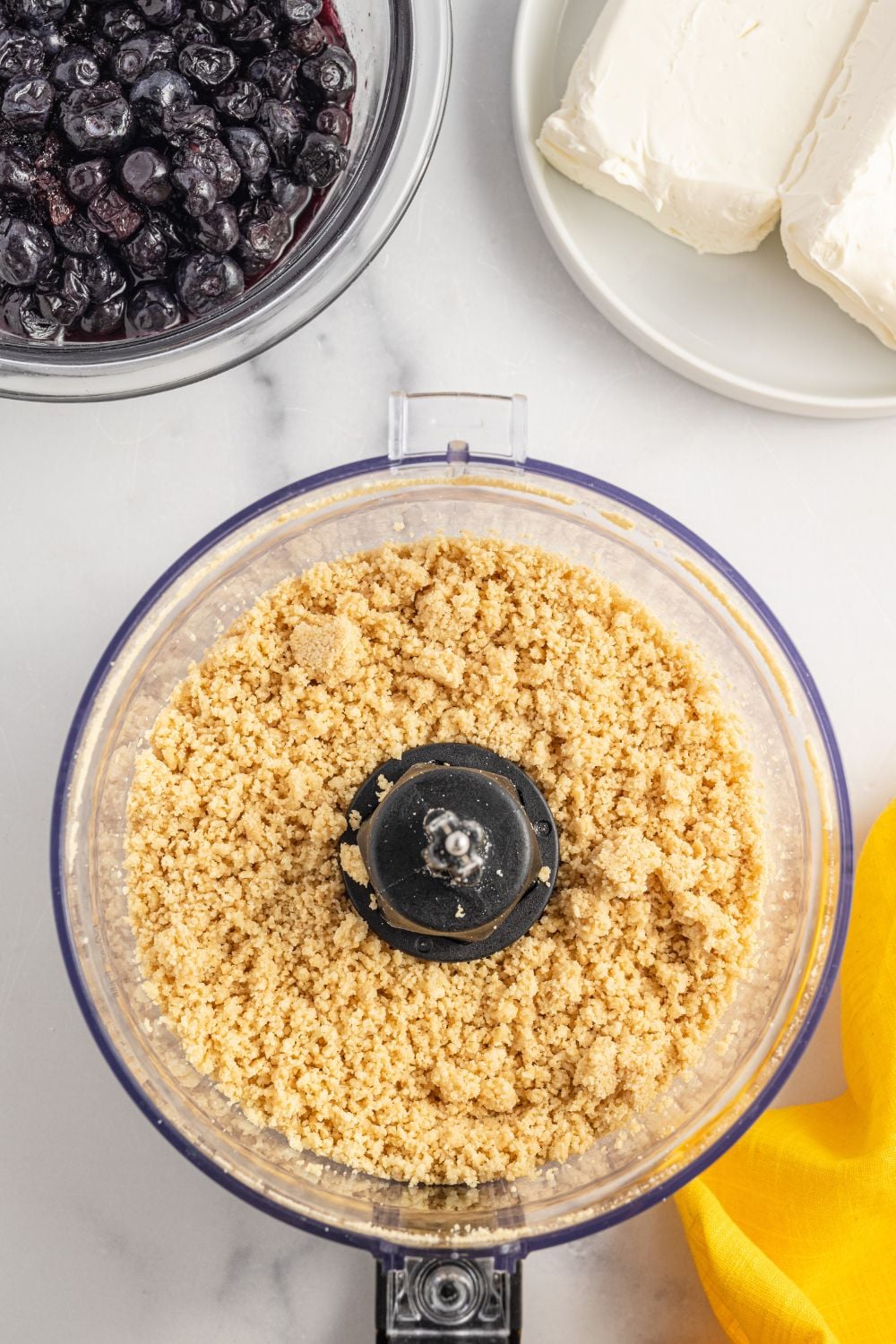 crushed graham crackers in a food processor on table