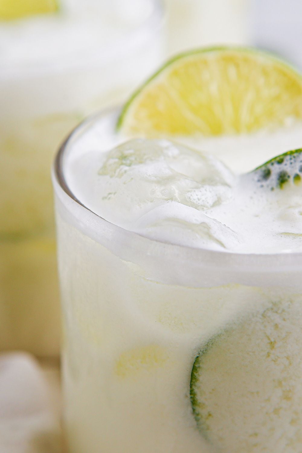 limade in glasses with a slice of lime in each glass