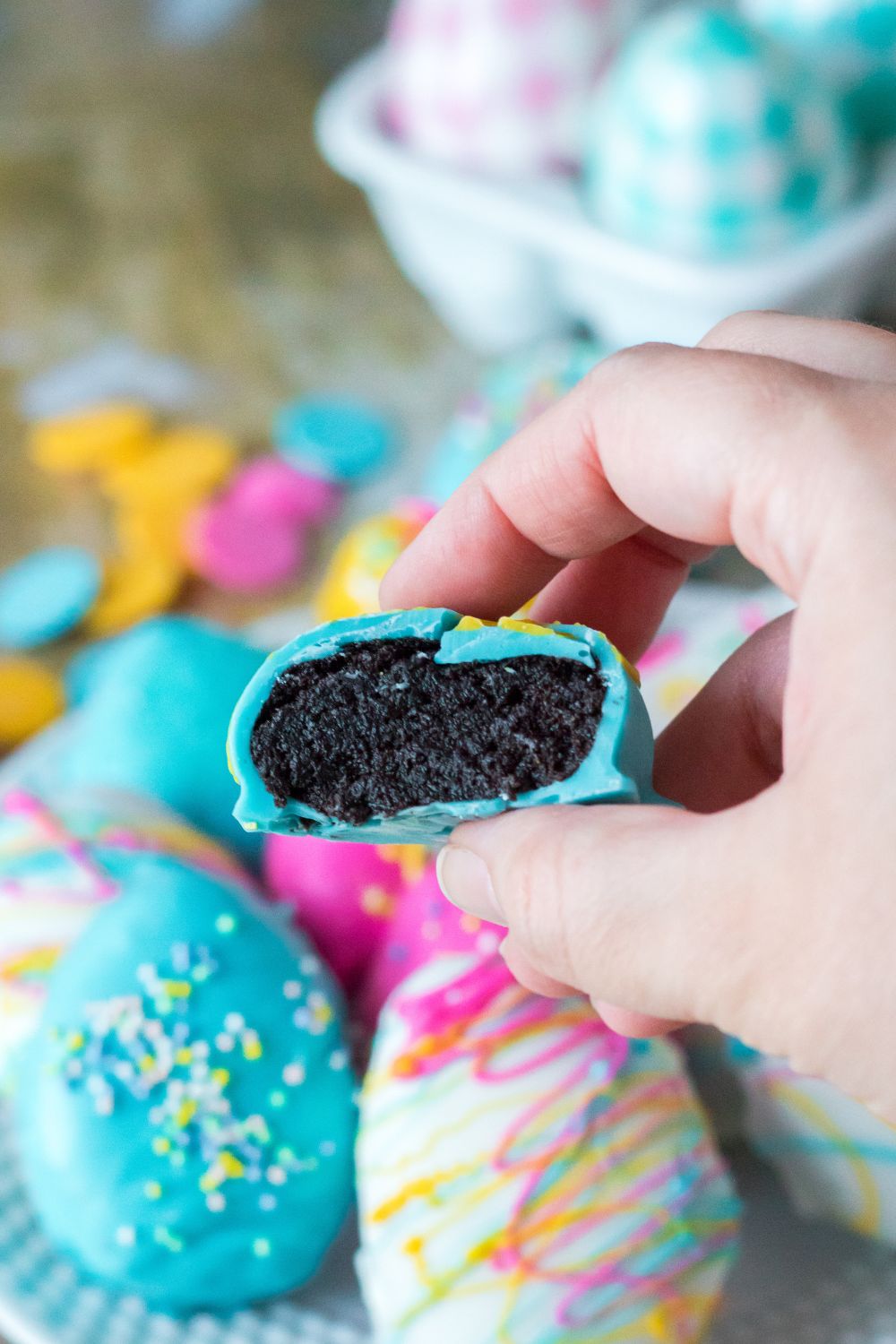 Easter Egg Oreo Truffle in hand with it bit in half