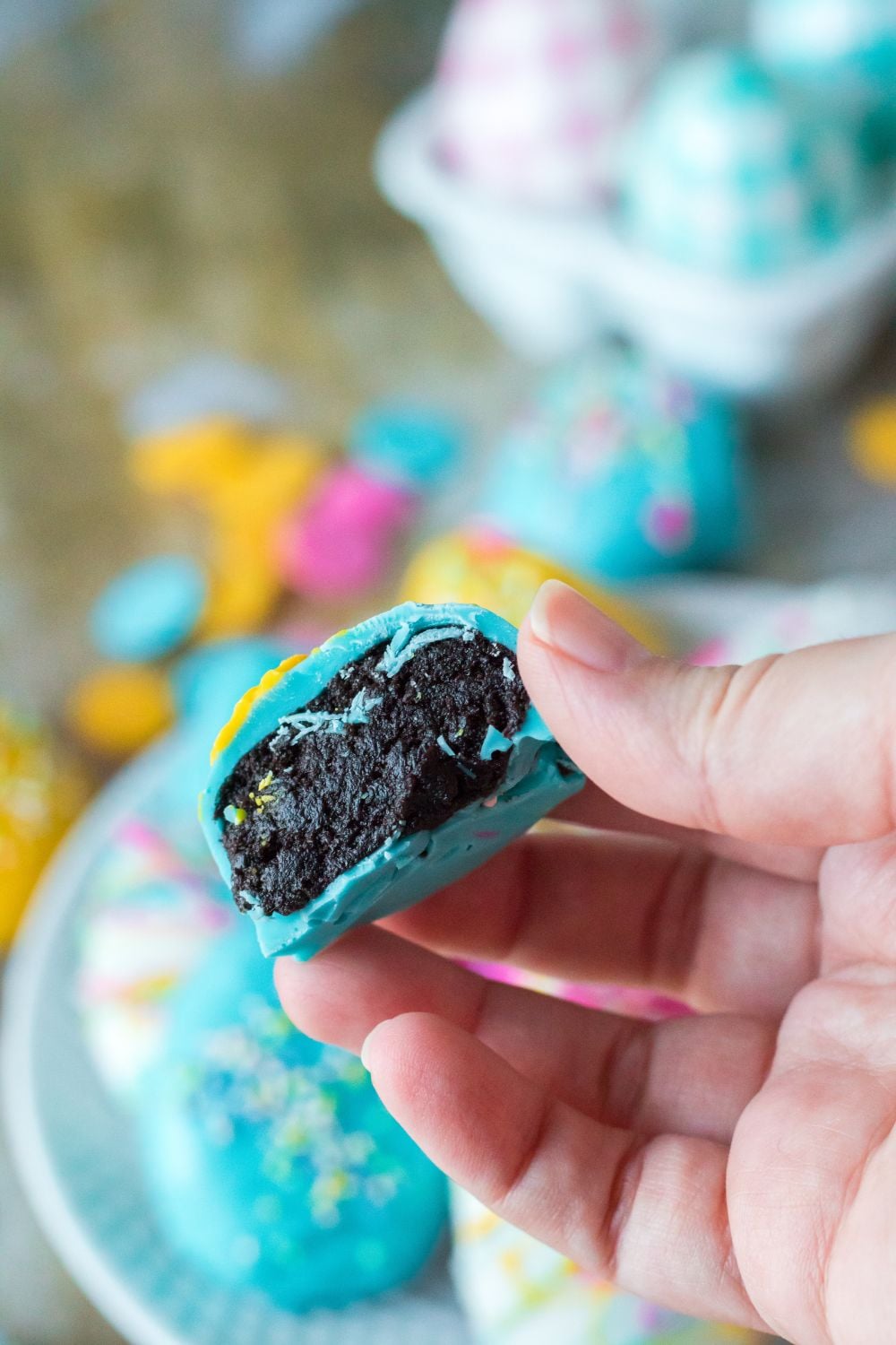 Easter Egg Oreo Truffle in hand bit in half to show the filling