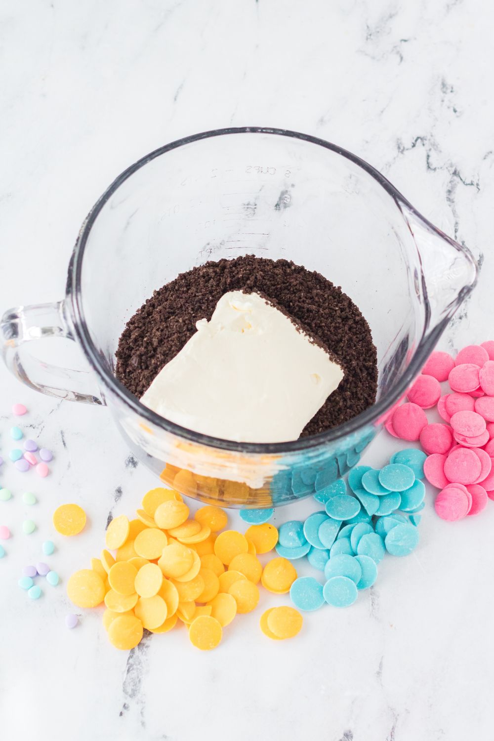 crushed oreos and a block of cream cheese in a measuring cup for the Easter Egg Oreo Truffles