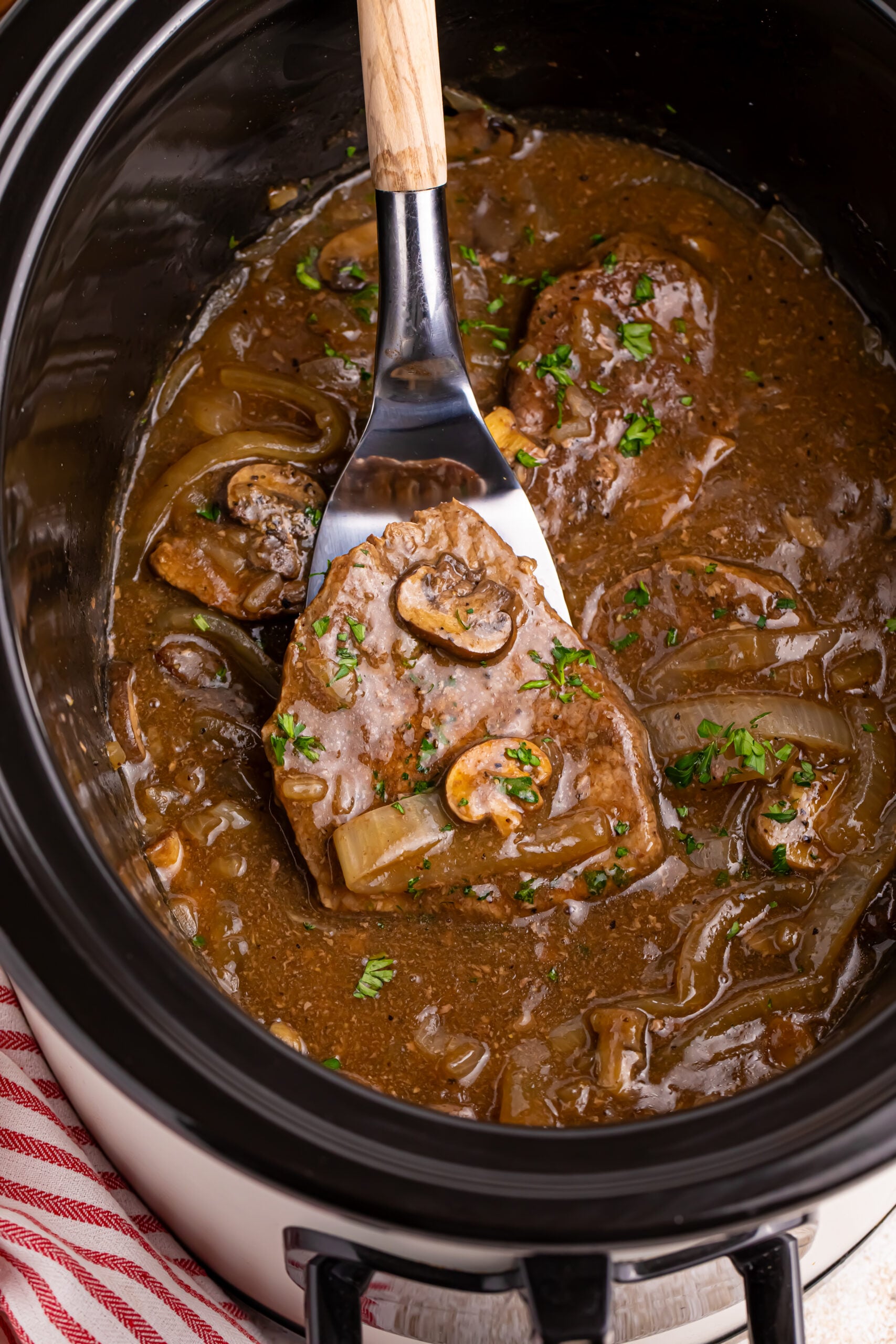 Crock pot filled with steak, onions and mushroom gravy