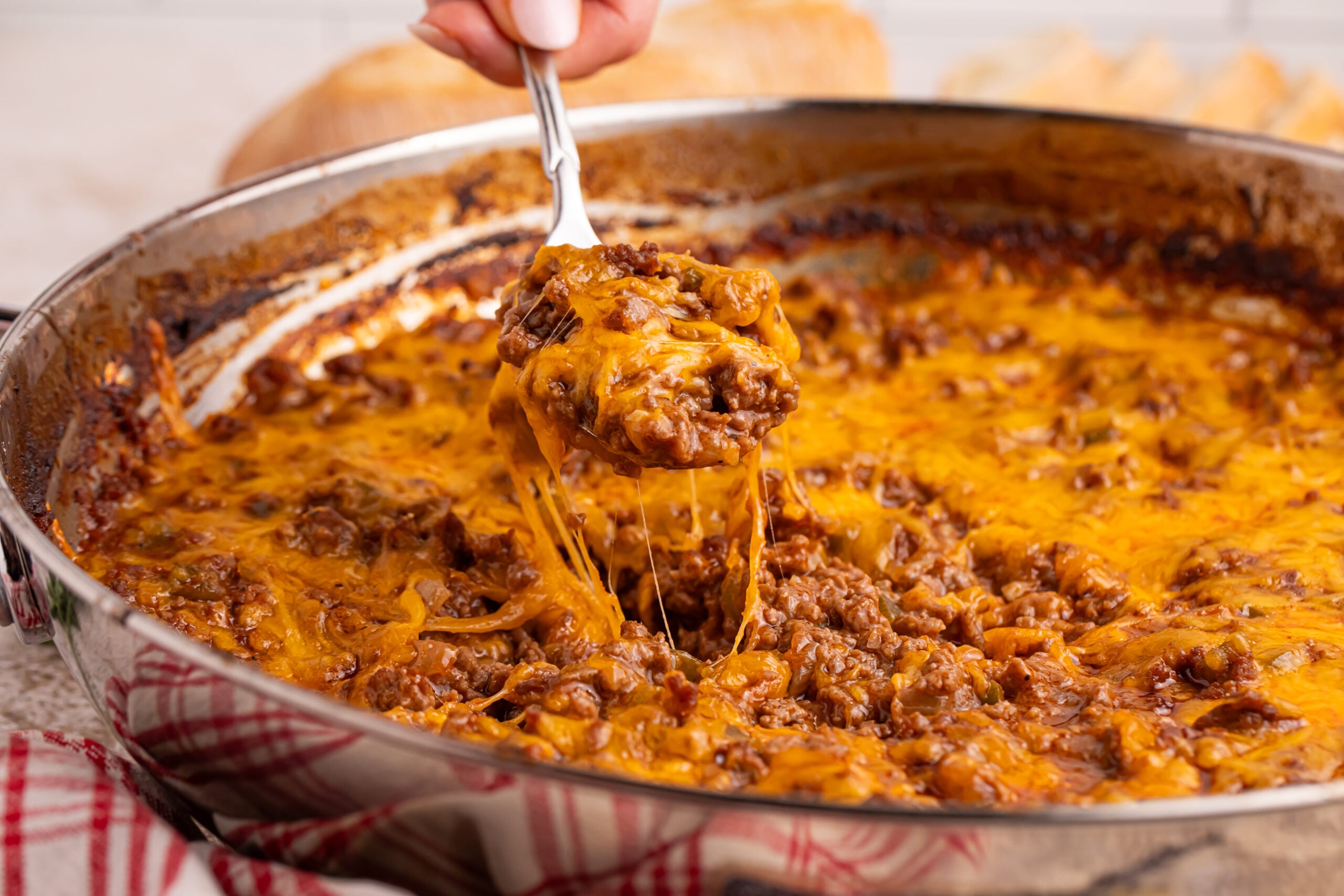 Sloppy Joe Dip in a silver pan with a spoon lifting out a bite
