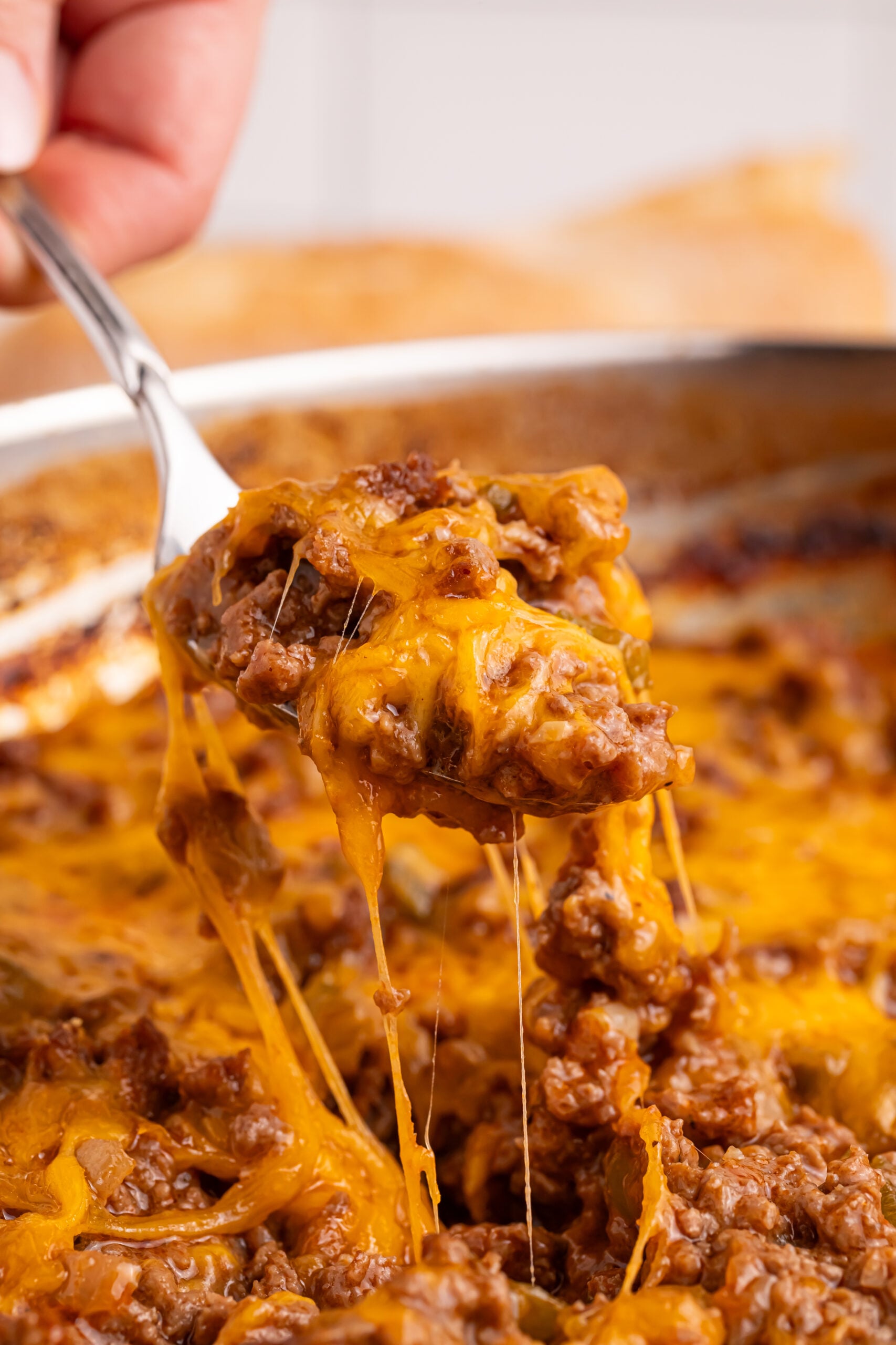 Sloppy Joe Dip in a silver pan with a spoon lifting out a bite