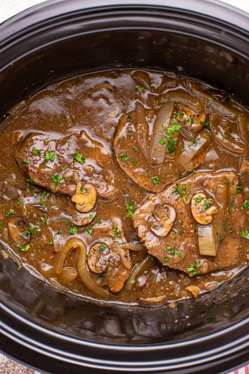 Slow Cooker Round Steak and Gravy overhead shot of steak smothered in gravy in slow cooker