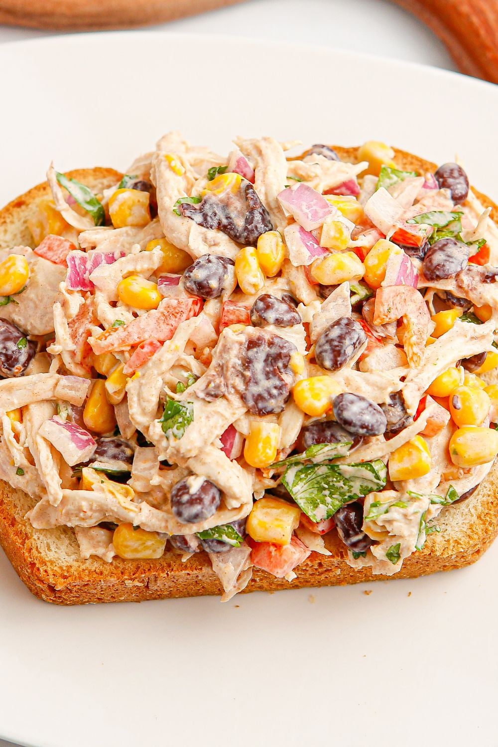 Southwest Chicken Salad on a slice of bread sitting on a plate