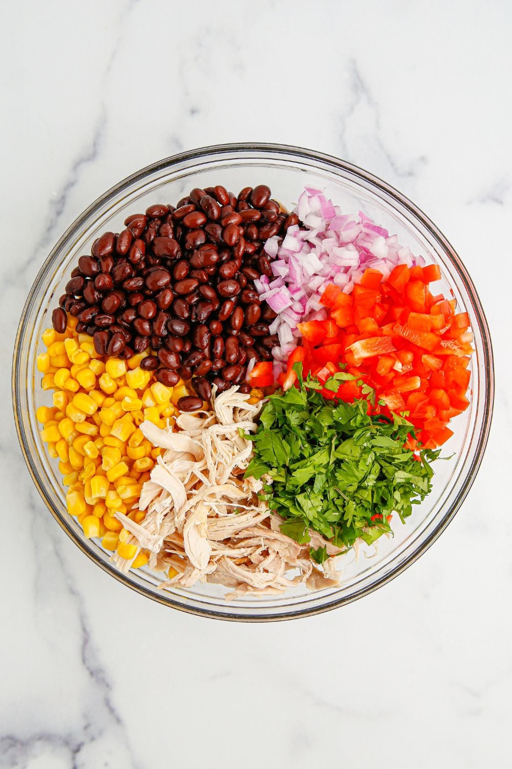 chopped ingredients for the Southwest Chicken Salad in a glass bowl sitting on the table